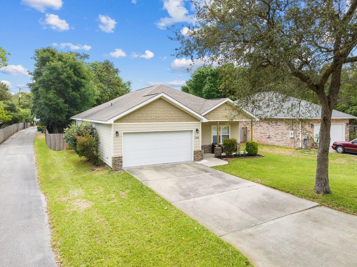 This attractive villa-style home sits on a quarter-acre lot in a well-established neighborhood. It has generous covered porches to front and rear providing ample space for outdoor living. Recent updates include a new HVAC, dishwasher and fresh paint in the bedrooms and baths. The fully-fenced backyard is kept lush and green with an automated sprinkler system. Inside, the open floor plan has gleaming wood flooring and raised ceilings, creating a bright and airy great room for family living and entertaining. Sliding doors provide a seamless flow to the screened porch. The kitchen has a wide, angled breakfast bar separating it from the dining and sitting area while still being open for conversation. Busy cooks will appreciate the vast granite countertops, travertine tile, stainless steel appliances and walk-in pantry for storing everything neatly out of sight. Enter the master bedroom and admire the tray ceiling and walk-in closet. The adjoining master bath has twin vanities and a linen closet. All on one level, two additional guest bedrooms are generously sized and share a family bathroom. A large laundry room provides additional storage space and leads to the two-car garage. This well-located home is close to Fort Walton Beach and minutes from Eglin, 7th Group, Duke Field and Hurlburt AFB. Supermarkets, restaurants and eateries are all nearby along with fishing and watersports on the bayou. The white sandy beach, pier and attractions at Okaloosa Island are just four miles from the door.