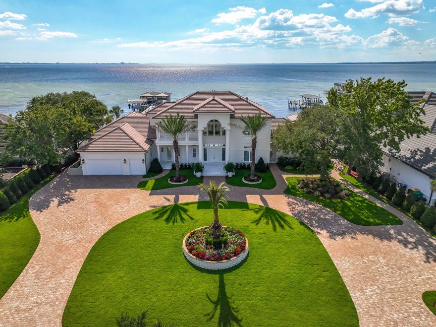 Welcome to 6 Sunset Beach Place, an extraordinary bay front estate in the gated community of Sunset Beach within Bluewater Bay. Set on nearly an acre of land with 151 feet of pristine waterfront overlooking beautiful Choctawhatchee Bay, this 6 bedroom, 6.5 bath dream home offers 6,424 square feet of luxury living. Every detail has been professionally designed and no expense spared with over $1.8 million in thoughtful renovations blending timeless architecture with modern sophistication.Almost every room provides gorgeous panoramic views of the bay. This home features new engineered hardwood and designer tile flooring, 12-foot ceilings on the first level and 10-foot ceilings on the second level, solid wood interior doors, arched openings, and plantation shutters throughout. The expansive open-concept layout includes a chef's kitchen with white oak cabinetry, marble countertops, Thermador professional appliances, an imported French oven, and a butler's pantry with custom built-ins and quartz accents. A coffee and wine bar and prep kitchen provide added convenience for entertaining.
Elegant living spaces flow seamlessly to the outdoors, where expansive patios and balconies capture stunning bay views. The sparkling pool and hot tub with new PebbleTec finish offers a more natural texture that delivers enduring elegance and durability.  A brand new outdoor kitchen, complete with a premium Coyote grill and appliances, sets the stage for unforgettable outdoor dining. Featuring elegant Taj Mahal quartz countertops, sophisticated Synergy wood details, and convenient remote-controlled awnings, it's the ultimate setting for any gathering while the fire pit and 12-color programmable pool lighting add to the ambiance. The air conditioned pool house offers a full bathroom, changing area, and shower.  
Every mechanical system has been upgraded, including five HVAC units, new water filtration and soft water systems, a Generac generator, impact-rated sliding glass doors, and a new concrete tile roof. The insulated and air conditioned oversized 3-car garage features new doors, epoxy flooring, and abundant attic storage.  Expanded parking added offering plenty of space for family, friends, and entertaining guests.  Smart technology enhances comfort and security with a full camera system, doorbell, sound system, and smart lighting throughout.
Designed by Amy Killebrew of Sinkler Designs, the home showcases $320,000 in custom ArtisanBilt cabinetry, Taj Mahal quartz, marble finishes, and designer fixtures. Two new gas fireplaces, located in the living area and primary suite, add warmth and charm. 
The west wing offers a private kitchenette and entrance, ideal for guests or multigenerational living.
Outside, the reimagined landscape adds a southern tropical oasis featuring gorgeous palm trees, plants and trees designed for privacy and low maintenance.  Professional lighting, brick pavers, and custom gates. 
Enjoy bayfront living with a shared dock and boat lift, perfect for days spent on the water.
Sunset Beach is an highly sought after neighborhood known for its serene lakes, fairways, and bayfront homes. Residents enjoy access to a private clubhouse, pool, and beach overlooking the bay, along with the amenities of Bluewater Baytennis courts, a marina, boat launch, and championship golf. Ideally located near the Mid-Bay Bridge, this home offers quick access to Destin's sugar-white beaches, fine dining, and entertainment while remaining just minutes from Niceville's top rated schools and Eglin Air Force Base.
6 Sunset Beach Place is more than a homeit's a statement of refined coastal living in one of the Emerald Coast's most desirable communities.