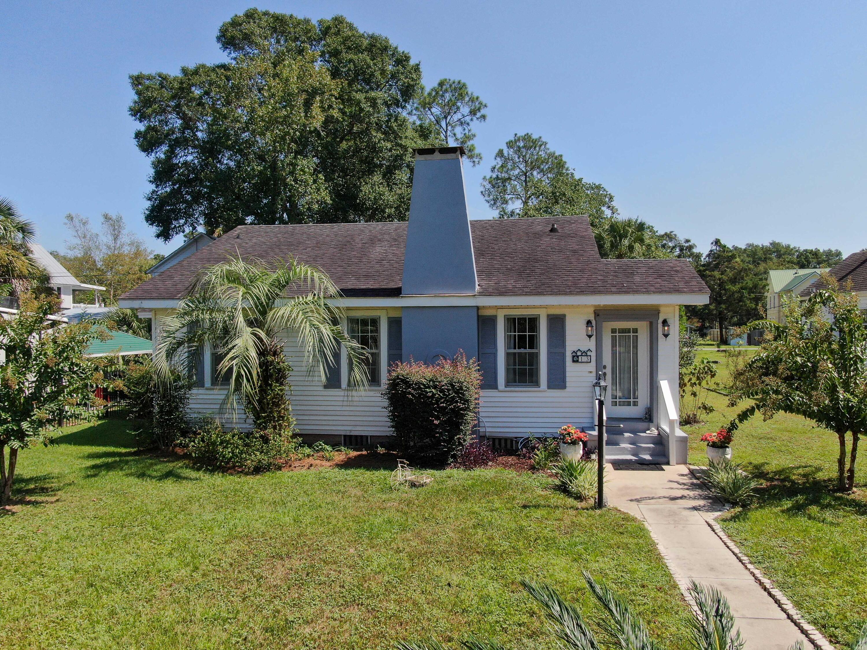 A beautiful blend of original historic features complemented with tasteful updates creates the perfect combination for this rare opportunity to own this one-story cottage less than 2 blocks to Lake DeFuniak in historic downtown DeFuniak Springs. Upon entry, you will find tile and hardwood floors in excellent condition and throughout the entire home (no carpet!). The natural gas fireplace will keep you cozy and mess-free during the chilly north FL months. You'll enjoy the well appointed kitchen with painted creamy white cabinets, solid surface countertops and newer SS appliances. The layout is efficient and yet you'll find plenty of storage. The dining area is accented by painted wood walls adding to the overall charm. There are 2 master beds and 2 baths with the option of a 3rd bedroom in