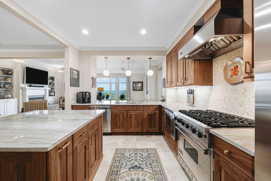 Elevated on the coveted fourth floor, this exquisitely renovated residence at One Water Place at Kelly Plantation offers breathtaking views of Choctawhatchee Bay and the Fred Couples Signature Golf Course, paired with unmatched convenience and accessibility. Designed for those who appreciate sophisticated living, this two-bedroom, two-and-a-half-bath home is a seamless fusion of elegance, functionality and modern luxury. Step inside from your private elevator vestibule to a bright, open floor plan adorned with gleaming white oak hardwood floors and custom crown moldings. The gourmet kitchen is a masterpiece, featuring custom solid walnut cabinetry with pullouts, exotic quartzite countertops and a striking recycled glass tile accent wall. A custom marble backsplash in the primary ensuite and tasteful neutral wallpaper in all bathrooms add layers of refinement. The expansive balcony is an entertainer's dream, boasting a newly installed outdoor kitchen with a gas grill, refrigerator, custom cabinetry and a stunning stone countertop. Thoughtful upgrades continue throughout, including electric roller blinds in the living room and master bedroom, motion-activated LED lighting in closets, new Carrier HVAC systems, a towel warmer in the master bath and polished travertine floors. Designed for full-time or part-time living, this non-rental community offers world-class amenities, including a bi-level heated lap pool, spa treatment rooms, a 5,000-square-foot fitness center, a wine tasting room with private lockers, bocce ball courts, putting greens, a dog park, walking trails and an equestrian center. Two underground parking spaces and a private storage room provide added convenience. Completely move-in ready, this exceptional home delivers unparalleled value in one of the most sought-after communities along the Emerald Coast.