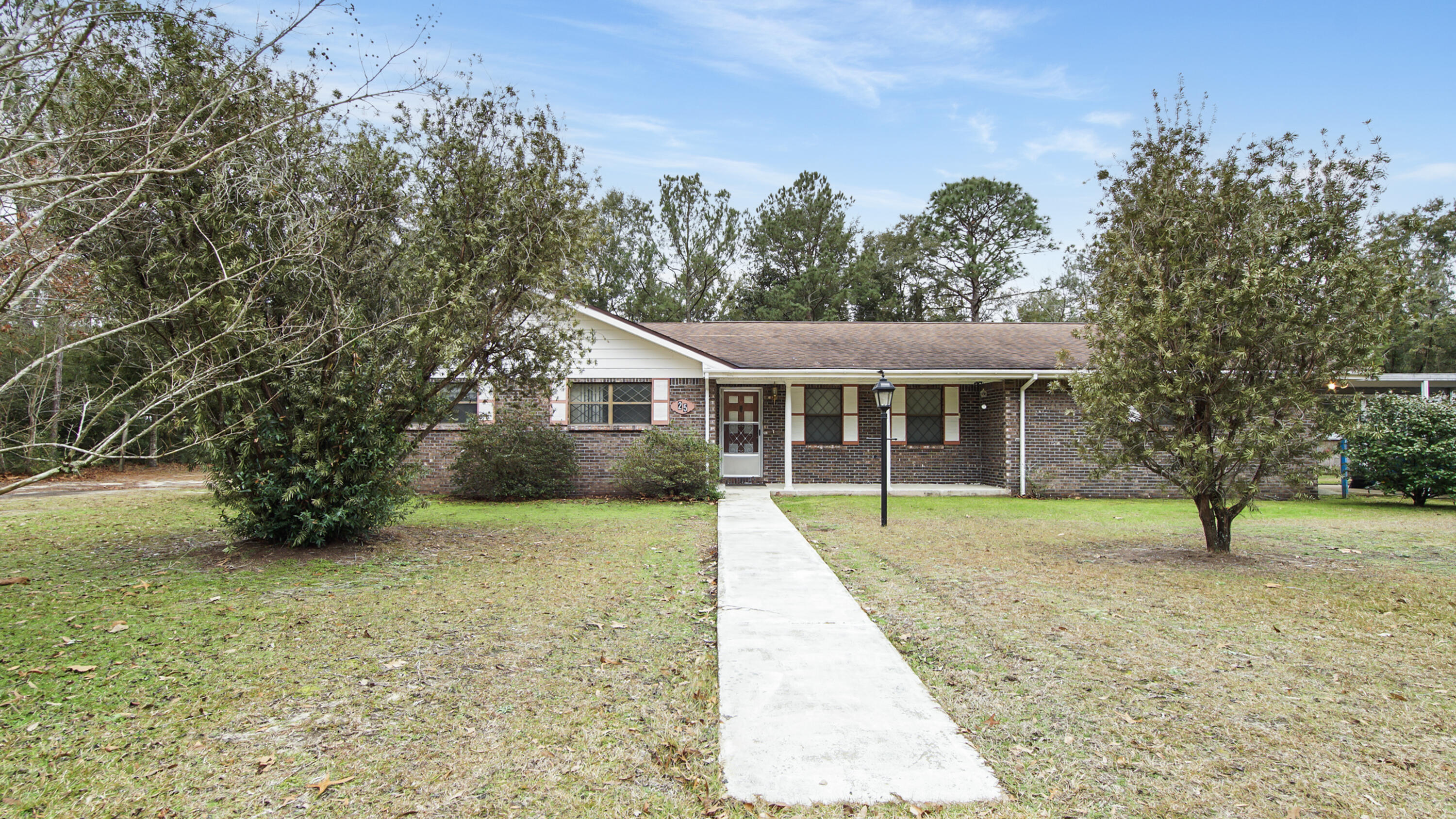 This 5 bedroom/3.5 bath brick home sits on 2 lots in a cul-de-sac across from Lake Rosemary. All bedrooms and bathrooms are on a single level, presenting a functional layout with plenty of space. The home is a solid structure with generous square footage provide a strong foundation for cosmetic updates and renovation. Seller states the approximate age of the roof is 7 years and HVAC is 3 years new. The second lot offers potential for future development, whether as a separate build site or an opportunity to sell. A rare combination of size, location, and investment potential in an established neighborhood. The spacious living room with impressive brick fireplace opens to the large back with several storage buildings. Located less than 10 minutes to downtown historic DeFuniak Springs, FL.