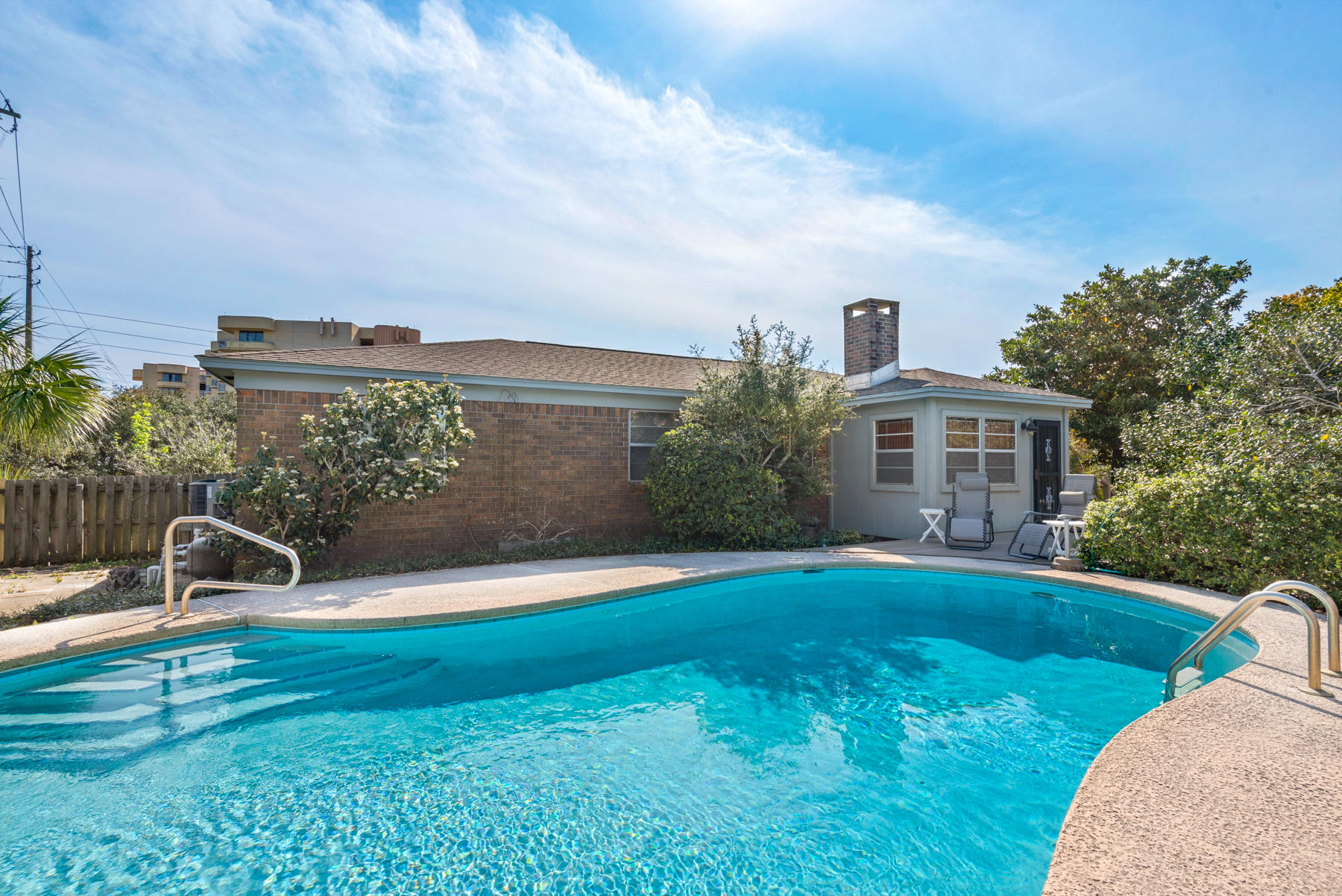 Swim in the Gulf of Mexico or walk on the beach - a mere 100 yards away from this enchanting Okaloosa Island home. Enjoy the amenities of island living, then retreat to a private .38-acre oasis abutting dedicated access to Santa Rosa Sound. Well-sited buildings and mature plantings create a secluded sanctuary featuring courtyards, gardens, patios, decks, covered and enclosed porches and an in-ground pool. Extras include workshop/storage room and finished lavatory off oversized two-car garage, sizable brick-paved off-street parking, utility room next to kitchen, and hot/cold outdoor shower. Consider remodeling and adding a second floor for gulf and sound views to transform this continually-maintained, well-elevated property into a captivating haven. Directly across from beach access.