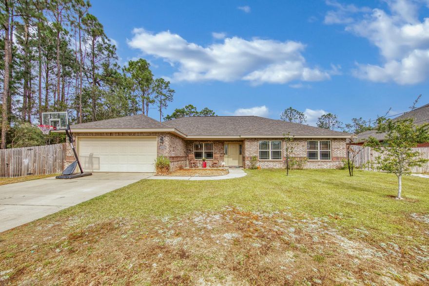 Beautiful 4 bed 2 bath home in Navarre is ready for a new owner!  Located only 3 miles from the beach.  It is situated on a very large fenced-in lot.  This home is very well constructed with brick and hardiplank exterior.  The home was built in 2014 and has 1972 square feet.  Brand new LVP flooring has just been installed in the living room and the bedrooms.  Tile flooring is in the rest of the home.  The spacious kitchen has granite countertops with stainless steel appliances.  With the weather cooling off, you will enjoy the nice fireplace this home offers.  NO HOA FEES!  This home will not last long!  Appliances and Washer/Dryer are being sold with the home.  Furnishings do not convey.  Home is in Flood Zone X.
