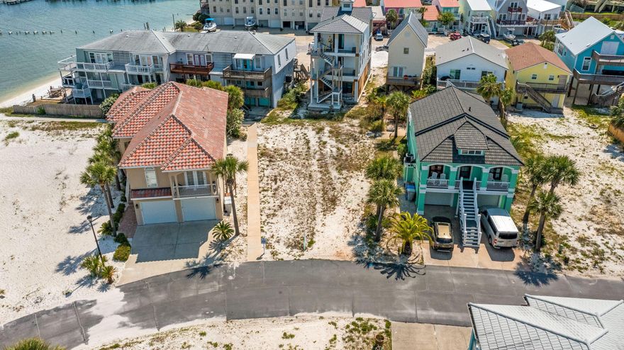 Welcome to the Village at Navarre! One of the most sought-after neighborhoods on Navarre Beach! A private quaint waterfront community, just a short walk from the sugary white sands of the Gulf of Mexico. Perfectly located on the Sound Side, offering the convenience of being close to dining, shopping, and events on the beach. Village at Navarre does NOT have RENTAL RESTRICTIONS and features a community pool, private beach on the sound, dock, and pier. The newly finished dock is equipped with power, water, and a fish cleaning station. If you love living the beach life, then now is an exciting time to build your dream home or a ''rental powerhouse'' STR.