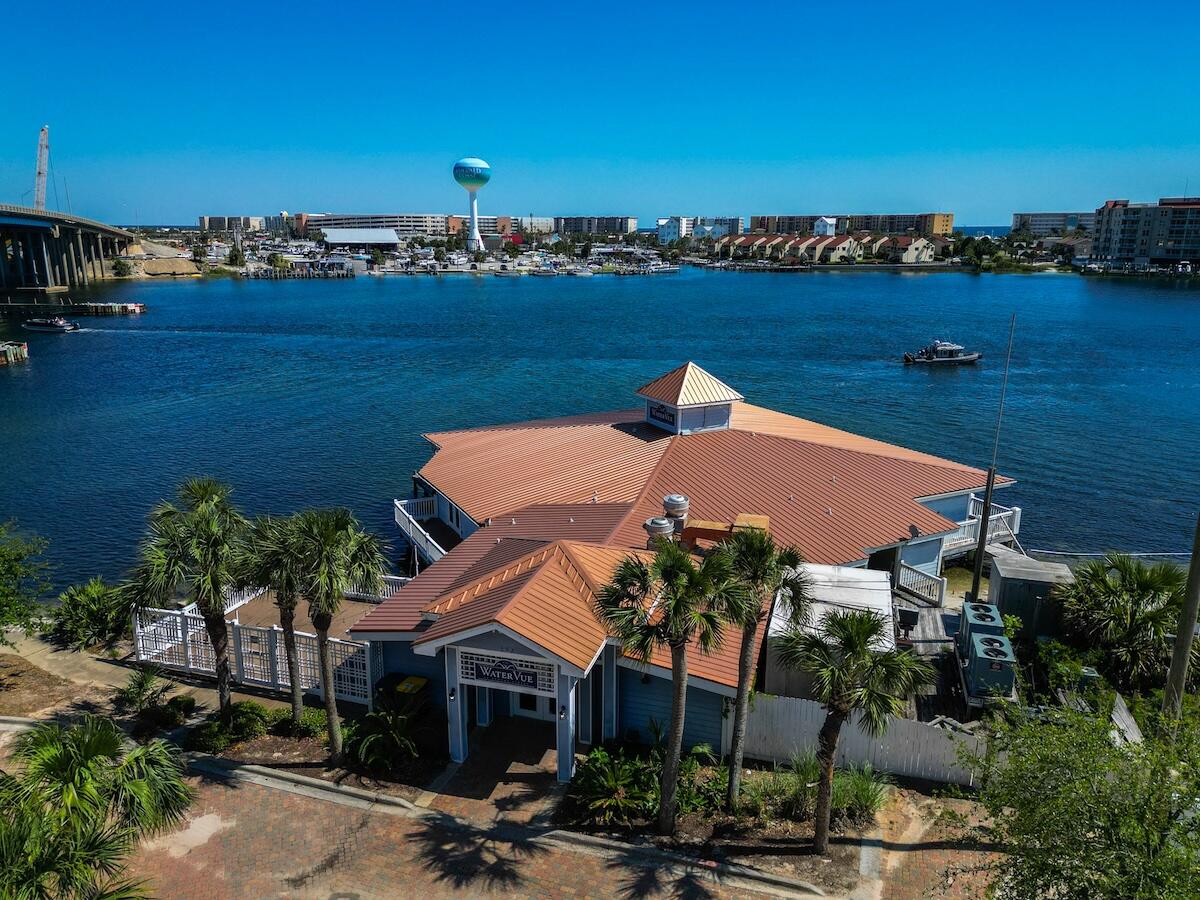 Here, on the sound side of Fort Walton Beach, is the premiere location of a unique commercial property. If the investor in you has ever thought 'wow, I should have bought that when it was available for $ because now it's worth $$$$', then seize this chance to make it happen for you!Brooks Street Landing Commercial Condominium consists of two buildings and the common elements which convey with this offering. First, the single-story multi-use building is located directly on and over Santa Rosa Sound. Its architecture extends over the water and lends itself to flexible marketing options including entertainment, corporate events, restaurant and lounge or other high-capacity seating needs. It is currently leased on demand. This building has many potential uses. cont'd The second building is a well-maintained, three-story commercial office building with each floor a separate commercial leasing opportunity. It has an elevator accessible to the lobby for each condo. The southernmost office areas have large windows which provide stunning vistas of the water.
Additional property features include a sub-lease of shared parking with city of Fort Walton Beach providing significant availability to park under the Brooks Bridge. There is potential for having the submerged State land lease at waterside of the property expanded allowing for a marina, subject to State approval. The panoramic views of the intercoastal waterway will be enhanced following completion of the new bridge which will be 15 feet higher than the existing bridge.