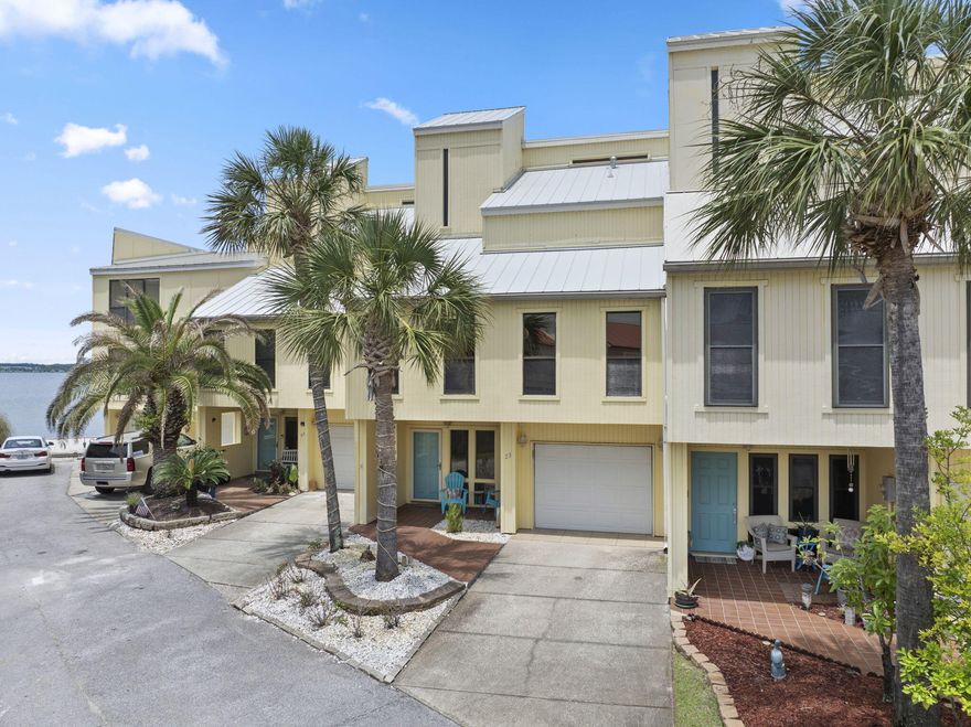 Welcome to waterfront living at its finest in the Buena Vida Townhomes on beautiful Navarre Beach! This spacious, move-in ready 4 bedroom, 3 bathroom townhome offers an excellent opportunity for your family's own Emerald Coast getaway, or your next short or long term rental investment property. With its own deeded boatslip on the Sound that includes a 10,000lb remote controlled boat lift, as well as a 2 car tandem garage - this townhome is perfect for water adventure enthusiasts and fisherman alike! Walking distance to the Navarre Beach Pier and local restaurants. The bottom floor hosts a large bedroom that includes its own ensuite bathroom and double french doors that lead to the back patio with a fantastic view of the Sound and easy access to the community beach, pool, and tennis court. Up the stairs to the second floor, you'll find gorgeous travertine tile and carbonized bamboo floors throughout the home and the open concept main living space. The Tuscan style kitchen features new stainless steel appliances as well as custom Diamond Reflection cabinetry and travertine countertops and is framed by beautiful arches to divide the kitchen and dining space. Just off the living and dining areas are impact rated glass doors and windows that flood the space with natural light - offering fantastic water views - and lead to the main terrace that overlooks the Santa Rosa Sound and features a remote controlled sunshade to keep it nice and cool for your outdoor entertaining. The 2nd floor also features 2 additional bedrooms and a full bathroom that also houses the laundry area and features a water closet with travertine tiled shower. The 3rd floor houses the primary suite, as well as a second living space or office space with floor to ceiling windows that offer an incredible waterview. The primary bedroom boasts its own private balcony and a spa-like ensuite with a Jacuzzi tub and separate tiled walk-in shower. This unit also has a loft through the primary bedroom that has 2 additional bonus rooms that could be utilized as extra bunkrooms, closet space, office space, or whatever your heart desires!