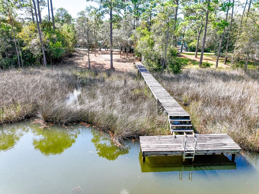 Discover your slice of waterfront serenity in the exclusive community of BayaPineaShores. This rare half acre+ homesite is nestled along a tranquil canal with direct access to ChoctawhatcheeaBay, ideal for building your primary residence or a dreamy vacation retreat.Picture mornings on your private dock (with an estimated 4'+ water depth) casting a line, paddling a kayak, or boarding your SUP. The peaceful bayou offers a perfect backdrop for boating, fishing, and water adventures.Location is key: you're minutes from the sugara'white beaches, vibrant shopping, fine dining and the full lifestyle found along ScenicaHighwaya30A. The lot has been recently cleared for easy visualization of your future home a' come walk the grounds & imagine your life here! Buyer to verify all information. Flood Zone AE