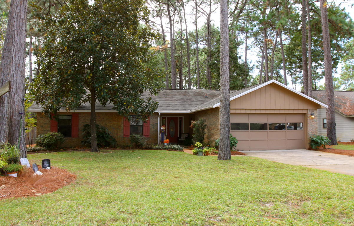 This charming Blue Water Bay home, perfectly situated in St. Andrew's Village near A+ rated schools and Eglin Air Force Base, only a short drive from shopping, dining, entertainment and the beautiful beaches of Destin, features a beautiful lot with large trees and mature landscaping with a nature trail that runs behind the backyard. An inviting front porch gives way to a proper entry way, once inside which leads to the light filled living room with a vaulted ceiling and a beautiful wood burning fireplace. The living room is open to a spacious kitchen and dining room.