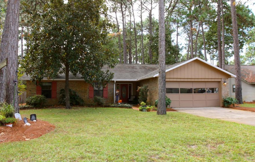 This charming Blue Water Bay home, perfectly situated in St. Andrew's Village near A+ rated schools and Eglin Air Force Base, only a short drive from shopping, dining, entertainment and the beautiful beaches of Destin, features a beautiful lot with large trees and mature landscaping with a nature trail that runs behind the backyard. An inviting front porch gives way to a proper entry way, once inside which leads to the light filled living room with a vaulted ceiling and a beautiful wood burning fireplace. The living room is open to a spacious kitchen and dining room.