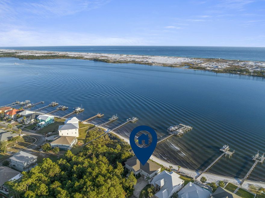 Immerse yourself in luxury and tranquility with this 4-bedroom, 3.5-bathroom custom-built residence, nestled in the coveted Sparkling Waters neighborhood on the Santa Rosa Sound.  Included is a deeded boat slip in the marina, complete with a 10,000 pound lift, that you can see right outside your windows. The impeccable curb appeal invites you into a world of panoramic intercoastal views, expansive living spaces, and unmatched style. Inside, 10-ft high ceilings adorned with striking crown molding harmonize with plank tile flooring throughout, all framed by elegant 5 1/4'' baseboards. The gourmet kitchen is a culinary enthusiast's dream, boasting custom ivory-painted cabinetry, sleek granite countertops, top-tier stainless steel appliances, including an oversized commercial-grade refrigerator/freezer, and a spacious pantry. 

The generously sized waterfront master suite is a haven in itself, featuring dual walk-in closets, a lavish en-suite bathroom with a glass-enclosed walk-in shower, a whirlpool garden tub, and a double vanity. For entertainers, the waterfront living room and dining area seamlessly merge, extending out to a vast covered porch perfect for alfresco moments. This home features waterviews from the Master bedroom, living room, formal dining room, and additional guest bedroom. Practicality complements luxury with features such as a conveniently located laundry room, a meticulously landscaped yard with a privacy fence, a sprinkler system, well, and timer.

The home's waterfront perks are in a league of their own, offering homeowners an island oasis outside. With breathtaking Gulf and Santa Rosa Sound views evident from the balcony and various rooms, the property stands as a testament to superior waterfront living. Residents will also be delighted with the charming private beach, a pristine swimming pool with custom stone decking, and a private stretch of white sugar sand beach. In 2020, the saltwater pool was built with a heater and measures 30x15.  The bonus spacious covered outdoor area, stemming from the finished concrete below, adds to its charm and is perfect for another entertainment space for family and friends just overlooking the water.  

Built on a classic piling foundation, the home's design exudes contemporary flair.  The residence's prime location, a few miles from Destin and just minutes from Navarre Beach, perfectly balances serene beachside living with proximity to lively attractions. In summary, this Sparkling Waters gem is ideal for boating aficionados, entertainers, or those who desire serene moments enveloped by cool sea breezes. Experience unparalleled waterfront elegance. (There is a boat available for purchase in addition to the home, if interested.)