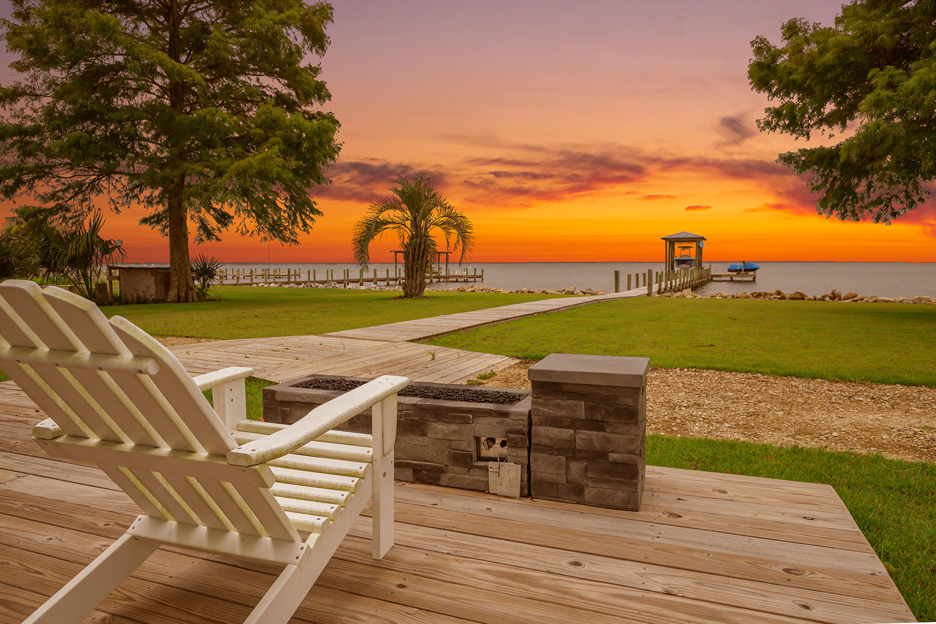 Bay Life at it's best!!!! Sunsets, water, & updated, beautiful living!!! This renovated home features 3BR each with their own patio with views. You'll love this cooks kitchen featuring a V groove wood ceiling, custom cabinets, marble counters, all new appliances including a Viking stove. The main bedroom is a lovely retreat & features a spa-like feeling in the bath with 4 ft walk-in shower & 7ft double vanity. This home has as much outdoor space to love as indoor....enjoy the views on covered and open patio spaces, gas fire-pit, 600+sqft boat house/dock w/boat & ski lifts, fish lights, and loading dock. Many practical benefits too...new AC/water heater, metal roof, front & back sprinkler system, recently reinforced sea wall. 20x15 workshop and 24x24 enclosed oversize garage.