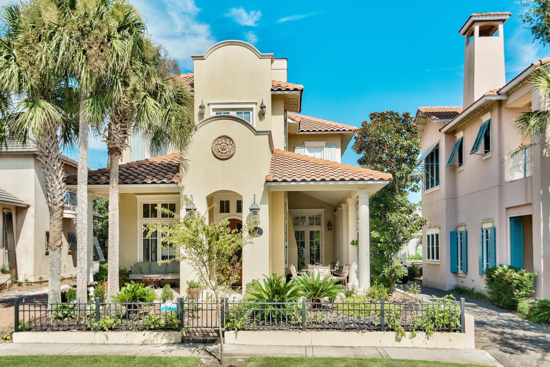 Photos coming soon of new Paint!Gated neighborhood of Caribe is on the beach and this home is a short stroll down the sidewalk to the community pool and Gulf! Custom designed by Christ & Associates, this Mediterranean Home features a wraparound front porch with stone columns, exposed beams, and outdoor fireplace. Through the arches, pass through the double mahogany door entry to a light-filled, 12-ft ceiling great room with fireplace, built-in media cabinet. Travertine throughout downstairs and hardwood upstairs. Enter the formal dining room on the way to an additional great room with chef's kitchen at the rear of the home overlooking a courtyard with hedged fountain. A detached guest house