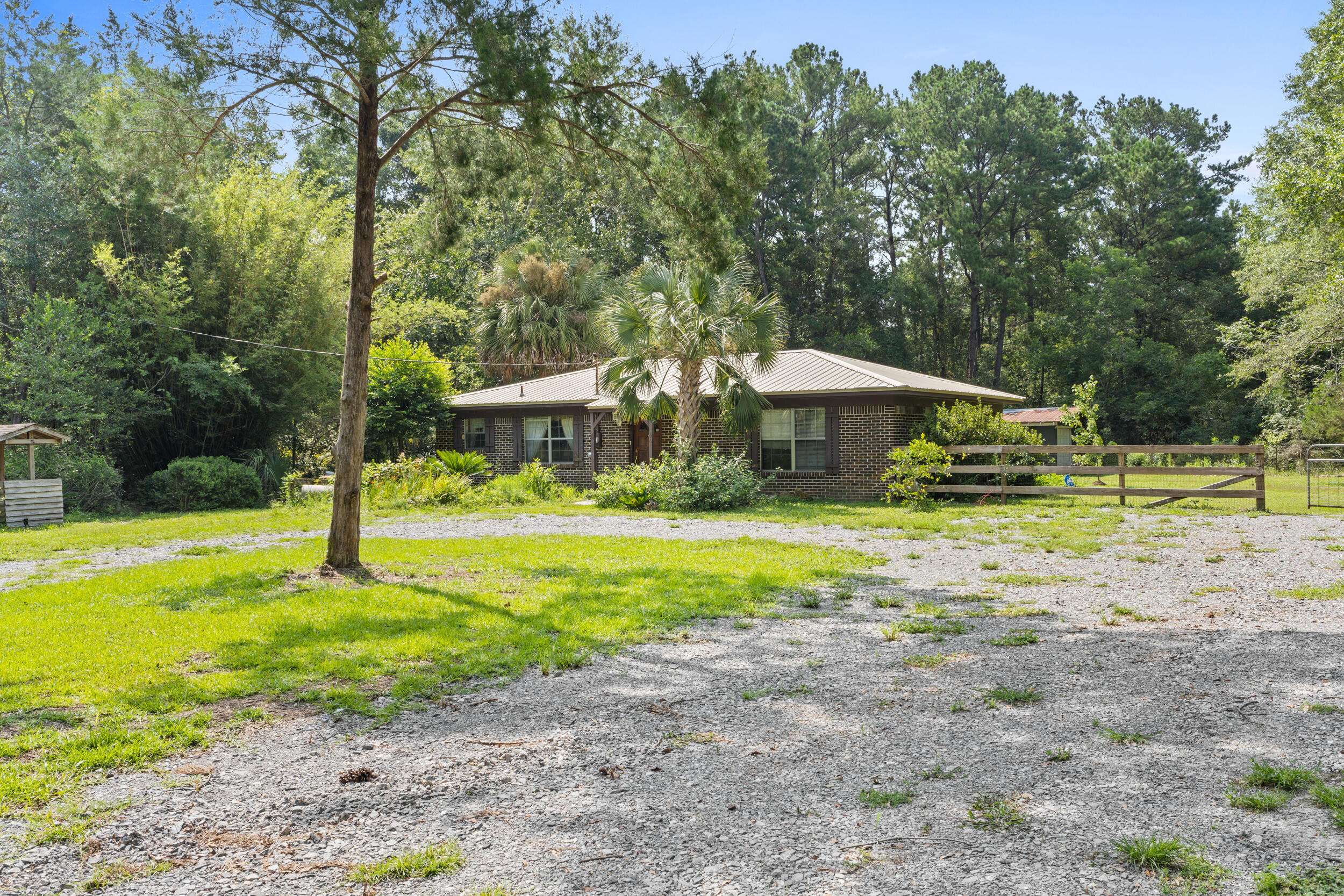Welcome to your new home! Nestled on a generous 1.4-acre lot just South of Defuniak Springs, this charming all-brick ranch style residence offers a warm and inviting atmosphere. Step inside and discover a thoughtfully updated interior featuring ceramic tile throughout, a stunning open kitchen, and modern light fixtures, creating a contemporary living space that exudes comfort and style. As you venture outside, prepare to be captivated by your own personal paradise. The expansive grounds provide ample room for your furry friends to roam, while two goldfish ponds add a tranquil touch to the landscape. Additionally, a secure fenced kennel area ensures the safety and happiness of your pets.
