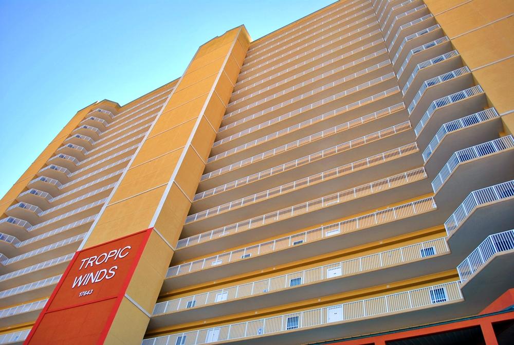 Awesome newer 3 bed/3 bath condo on west end of PCB with deeded parking space, over-sized balcony, low HOA, and priced UNDER 500K! 3 bedroom condos in Tropic Winds rarely become available for sale and this one is $89,000 less than only other for 3 bed for sale in building! Established rental record available for past three years, being sold fully furnished with calendar of bookings, beach chairs for 2018 and lock service! Great online ratings. Stainless appliances, trendy faux wood tile, granite breakfast bar, and very large bedrooms. Location is perfect second home option for eventual retirement or relaxing family friendly condo complex. Complex is clean and offers overflow guest parking, Gulf side pool, sauna, owners lounge and spa. Come see for yourself, you'll be delighted you did!