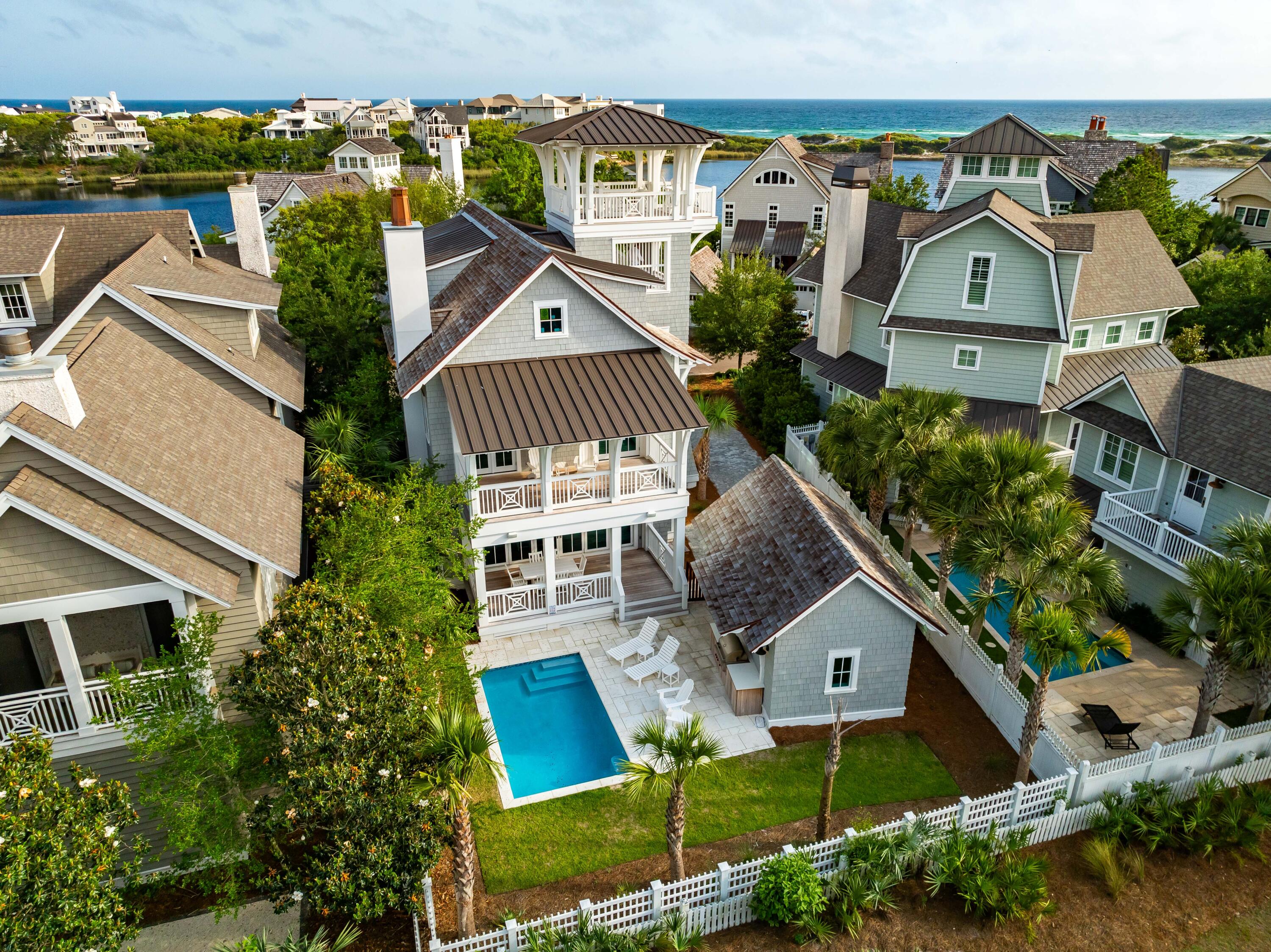 Revel in coastal sophistication at this exceptional 5BR/5.5BA residence encompassing nearly 3,300 square feet with a private pool, elevator, and detached one-car garage nestled in the prestigious Peninsula district of the gated WaterSound Beach community. This newly constructed masterpiece offers a rare blend of charm and functionality, boasting panoramic views of both the serene Camp Creek Lake and the shimmering waters of the Gulf of Mexico.Crafted with meticulous attention to detail, this home is a testament to modern coastal architecture. Notice the seamless integration of elements from the geometric detailing on the balconies to the cedar shake siding and roof shingles to the over 1,800 Sq Ft of Ipe decking on all outdoor porches. From the moment you arrive, you'll be captivated the seamless integration of indoor and outdoor living spaces. Step onto one of several expansive porches, including wraparound porches on both the first and second levels and a remarkable 4th-floor observation tower where breathtaking sunsets become a nightly ritual. 
The interior of the home is no less stunning with multiple rooms wrapped in shiplap, beamed and vaulted ceilings, abundant windows bathing the home with natural light, and designer touches evident throughout in the lighting fixtures and high-end furnishings. The bright and airy great room is the heart of the home with a gas fireplace with marble surround, Cypress ceiling beams, and Nano doors that open to a welcoming dining porch overlooking the pool. The beautifully crafted kitchen is a culinary haven with commercial grade appliances, marble countertops, a Moroccan-style backsplash, floor-to-ceiling cabinetry, and Oyster shell chandeliers over the generously sized island. One guest suite is located on the first level with three more including the primary suite on the second level, and another on the third level. Each ensuite features artfully tiled walk-in showers and luxury detailing in both the fixtures and cabinetry. Both the second and third levels include a landing space perfect for a media room or office space.
Designed for both comfort and entertainment, the outdoor pool area beckons with its tranquil ambiance and borders a lovely community park, ensuring utmost privacy for your gatherings. This property is located moments from the community trail to Camp Creek Lake and bridge to private community beach access. The driveway can easily accommodate four cars along with additional parking available in the one-car garage. The thoughtful design of this property makes it well suited to a variety of uses from an investment property to a personal retreat.
The gated WaterSound Peninsula community is located south of Scenic Highway 30A offering homeowners a rare sense of seclusion yet with easy access to area activities. Amenities include swimming pools, a puttering park, community green spaces, a state-of-the-art fitness center, and private boardwalks along the rare coastal dune lakes and leading to the beach and to one of the most beautiful stretches of coastline in the country. Owners also have the opportunity to join the Watersound Club by The St. Joe Company featuring: private beach access, beach services, pools, restaurants, a bar with gulf views, two private golf courses (Camp Creek and Sharks Tooth) and the brand new Lifestyle Center at Camp Creek.