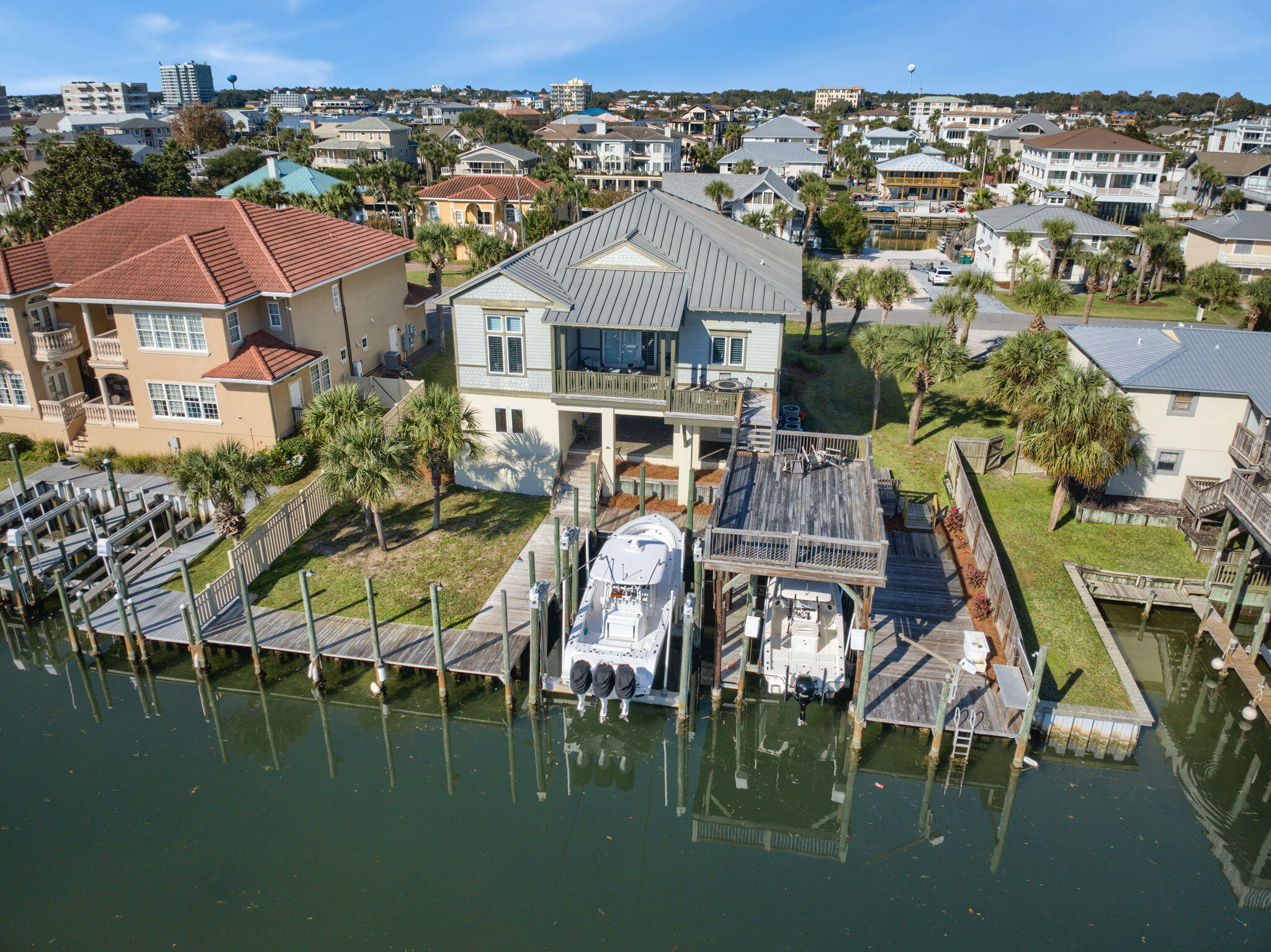 This home is located on Holiday Isle and offers the unique advantage of two private access points to the beach. Notably, Holiday Isle is one of only two areas in Destin that allow vacation rentals. Additionally, it's just minutes by boat to the Destin Pass, Choctaw Bay, Crab Island, and the Gulf of Mexico, making it an ideal location for those who enjoy coastal living and boating.This home boasts bright and spacious living areas, along with outdoor decks that provide the perfect setting for casual living and entertaining. An expansive 4-bedroom, 5-bath canal-front coastal villa which features a spacious kitchen and living room on the main living level, adorned with granite countertops, stainless steel appliances,