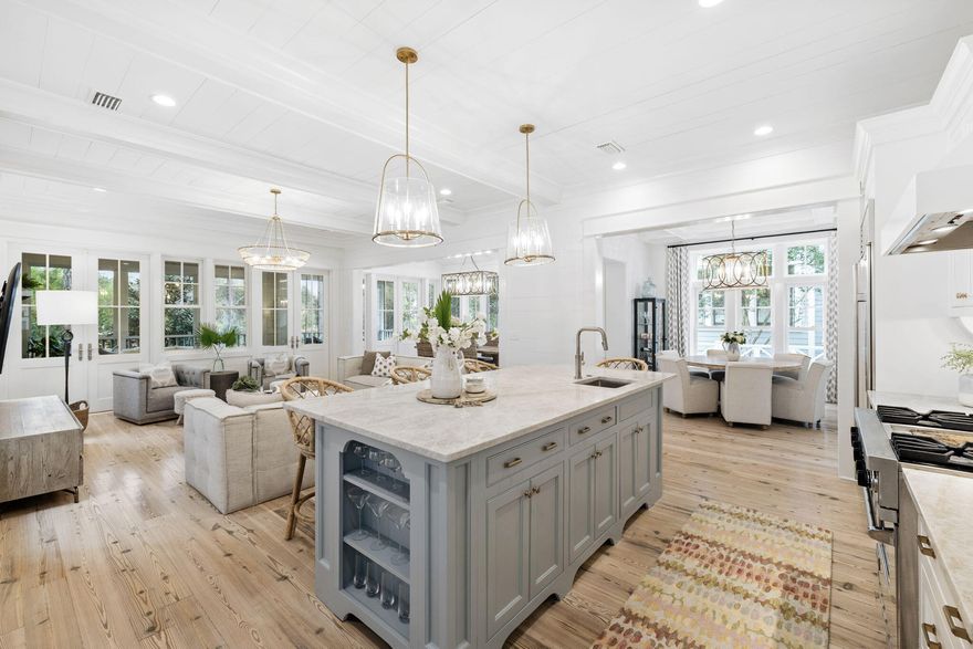 Featuring a beautifully renovated kitchen, this T.S Adams designed 5-bedroom, 5-bath coastal cottage retreat overlooks peaceful Yacht Pond in the exclusive gated, Gulf-front community of Watersound Beach.Designed for effortless coastal living, the home offers an open and inviting floorplan with abundant natural light, high ceilings and thoughtfully designed spaces that flow seamlessly from kitchen to living areas and outdoor gathering spaces. Designer furnishings and custom decor complement modern conveniences including smart home automation for lighting, climate control, leak detection, and security.At the heart of the home is the newly renovated main level kitchen, featuring a large island with Taj Mahal quartzite countertops, professionally painted cabinetry, elegant gold hardware  , modern fixtures, premium appliances and deep basin sinks. Beautiful statement lighting and bar seating make this space ideal for entertaining, while two dining areas provide flexible options for family meals and gatherings.
The living spaces open effortlessly to a new screened porch retreat, complete with a cozy seating area, bed swing, gas lanterns, and fireplace. Just beyond, a new custom fence encloses the private backyard, featuring a patio with charming bistro lighting and a gate providing direct access to Yacht Pond and Watersound's scenic walking trails.
Above the two-car garage, a private carriage house suite offers comfortable accommodations for guests or extended family with a bedroom, full bath, living area, eat-in kitchenette, and private balcony. A nearby grill patio conveniently sits between the carriage house and main home.
The main house includes four additional bedrooms, including a main-level guest suite and a charming built-in bunk room. The primary suite provides a spa-like retreat with a Juliet balcony, dual vanities, soaking vessel tub, and separate walk-in shower.
Upstairs, a secondary living and TV area offers additional gathering space, while a spiral staircase leads to a private office and sunlit tower room with kitchenette and Gulf views.
Located within the main gate of Watersound Beach, residents enjoy access to a private beach, scenic dune walkovers, coastal dune lake access, resort-style pools, dog parks, playground, dedicated post office, "Puttering Park", boardwalks, and miles of scenic walking and biking trails along one of the most beautiful stretches of 30A.