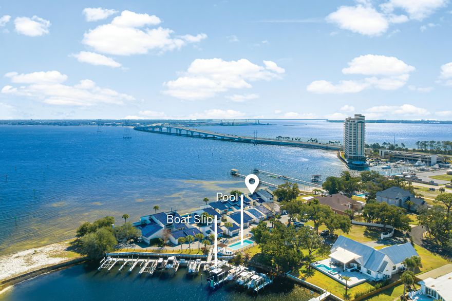Experience breathtaking bay views and effortless coastal living in this beautifully updated three-bedroom, two-bathroom townhome at The Moorings at Woodlawn Point. Spanning 2,394 square feet, this waterfront retreat is framed by majestic oaks draped in Spanish moss, offering a serene escape with modern comforts. Step inside to find soaring 15-foot ceilings and floor-to-ceiling windows that flood the open-concept living and dining area with natural light. The water views extend from nearly every room, creating a tranquil backdrop for daily life. Luxury vinyl plank flooring, sleek quartz countertops, and fresh interior paint give the home a modern, move-in-ready appeal. The master suite occupies the entire second floor, providing a private haven with panoramic bay views. The spa-like en-suite bathroom features dual vanities, his-and-her closets, a walk-in shower, and a floating bathtub  perfect for unwinding after a day on the water. Boating enthusiasts will appreciate the private boat slip equipped with a 16,000-lb. lift, offering direct access to the Gulf of Mexico and Shell Island. Whether you're setting off for a fishing trip or a leisurely cruise, your waterfront adventure starts right from your backyard. Additional highlights include an attached two-car garage and access to the community pool. Tucked away in a quiet 12-unit complex, this home combines the peace of a private marina with the convenience of nearby amenities. From morning coffee on the patio to moonlit reflections on the bay, every moment here feels like a coastal getaway.