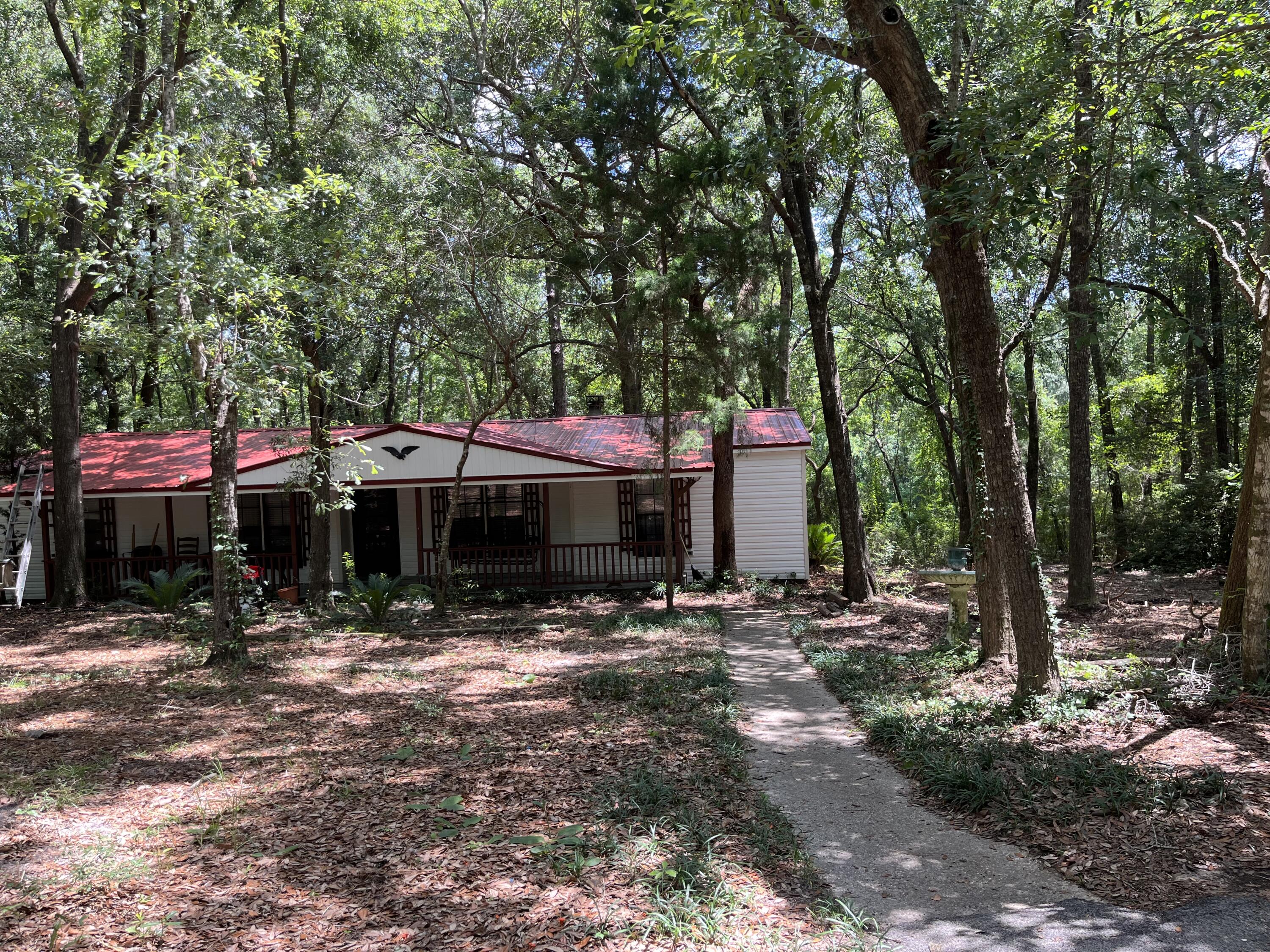 AS IS will not qualify for certain financing. Private retreat minutes to Twin Hills Park and downtown Crestview. As you come down the driveway, you will feel as if you are in the country. Mature trees throughout the property. RV parking pad as you continue down the long driveway, to the far side of the home. With the circular function of the driveway, easy access for RV parking. Spacious front porch to watch all that nature has to provide. Kitchen with separate dining room. Split floor plan with Master en-suite. The other two bedrooms share the second full bath. Spacious Florida room. Red metal roof. This property is being sold 'As Is'. Fixer-upper or Investor could add to rental portfolio. HVAC 2022, Appliances Convey AS IS
