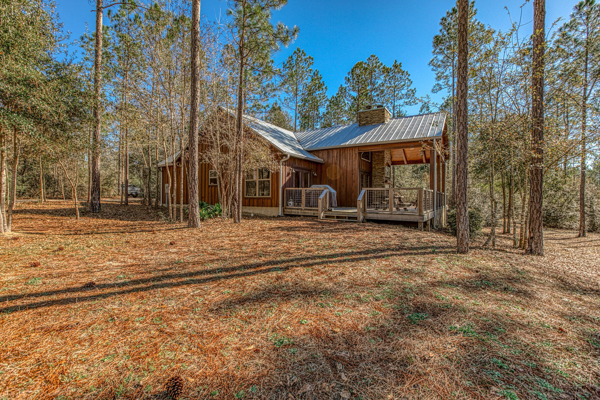 Custom Florida-style cypress cabin on 90 acres in Walton Plantation perfect for full time home or weekend getaway and only 45 minutes to the Gulf of Mexico beaches.  Many custom features including two fireplaces, kitchen with stainless appliances, convection oven, convection microwave, under-counter ice maker, washer-dryer.  This is an entertainment friendly cabin with a large open gathering room with vaulted cypress ceilings and large outdoor deck.  Large barn with enclosed, lockable storage area.  Orchard with blueberry, pear, peach trees.  Multiple garden plots with irrigation system.  Acreage has extensive trails and paths for walking and riding.  This property is turn-key ready!  Enjoy all that walton plantation has to offer including gated access, hunting areas, ATV riding etc!