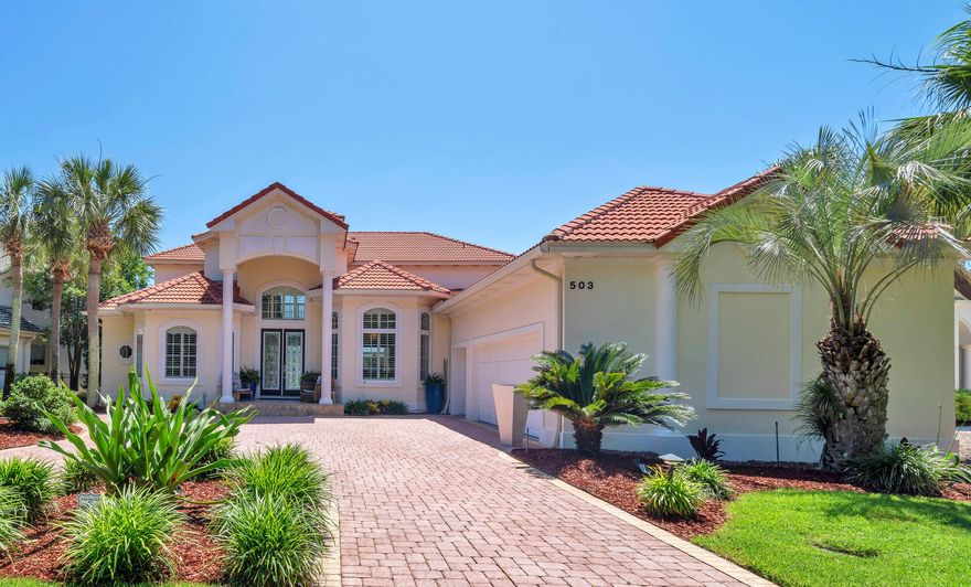 It's all about the VIEW! 503 Regatta Bay blvd is located lake front across from the 16th tee (no golf balls hit your home) in the prestigious Regatta Bay Lakes neighborhood.  This custom built home is excellent for entertaining with 20' ceilings, wide open spaces, a grand staircase, disappearing sliding glass doors that open on to the screened in pool lanai with non slip tile, hot tub, built in outdoor kitchen and plenty of room for seating that allows for al fresco dining while you watch the sunset nightly and fireworks 3 times a year bug free.  The pool bathroom helps keep water contained outside and comes with a shower to wash off the sand from the beach only 1.5 miles away.  There are door alarms for peace of mind with little ones too.  The gourmet kitchen has custom dovetailed *Schrock cabinets, built in  SubZero fridge, 6 burner Dacor gas range, built in Thermador oven and microwave, a Miele dishwasher, and a wine/drink fridge. New emerald pearl quartzite countertops, a deep Blanco granite sink with a hot water dispenser and a water filter system along with a custom center island with a wood Boos block top complete the space.  

This multigenerational home offers 2 large primary suites on the main level on opposite sides for privacy.  The main master wing has 2 large walk-in closets with built in organizers and the other is ADA equipped and also has a large walk-in closet.  Both suites have sliding glass doors that open on to the screened in lanai and oversized bathrooms with *Schrock custom cabinets and tons of storage. The large bright laundry room off the main primary wing has a huge picture window that adds lots of natural light, has more storage and is also accessible from the hallway off the 2 ?? car garage.  

A dedicated office off of the sitting room has lots of storage with 2 custom built in desks and custom cabinets and shelving.

There are 2 additional bedrooms upstairs with new light white oak hardwood floors.  Bedroom #3 has an attached fully remodeled bathroom and the versatile bedroom #4 has a kitchenette with new quartz countertops, seating and storage, a small sink, 2 mini fridges, and a small dishwasher. A spacious bedroom, guest suite, or media room as owners currently use the space, great for watching the game with friends and family. The bunkroom can be a massive walk-in closet or an ensuite bathroom depending on the next family's needs.   

The upstairs spacious screened in covered lanai has amazing views of the golf course, lakes, and skyline and is perfect for reading a book or relaxing.

Too many updates to list (full list is attached to MLS) to include 2 new HVAC units, new hot water heater, new pool pump, new quartz in laundry room, new granite installed in outdoor kitchen with custom tile backsplash wall for easy clean up, interior recently painted, new ceiling fans, 8 new screen panels replaced after SNOW! 

Tile floors downstairs are easy to keep clean (sand) and newer carpet is on stairs and landing only.  

Owners also have a 4 point inspection report and wind mitigation report dated 10/2024 for low home insurance available.  There is a Generac whole home generator, 2 termite bonds grandfathered in to the property and a charger for an electric car out front on the side of the home.  

Regatta Bay is a private gated community within walking distance to shopping, dining, Whole Foods, Destin Middle School, Lulu's, Legendary Marina and the beautiful Destin beaches.  A perfect oasis, rated a top GOLF course by Golf Digest magazine, rated the safest community in Destin.  Come experience the Regatta Bay lifestyle and make 503 Regatta Bay your home today.  Video is available on Youtube, look up by address.
