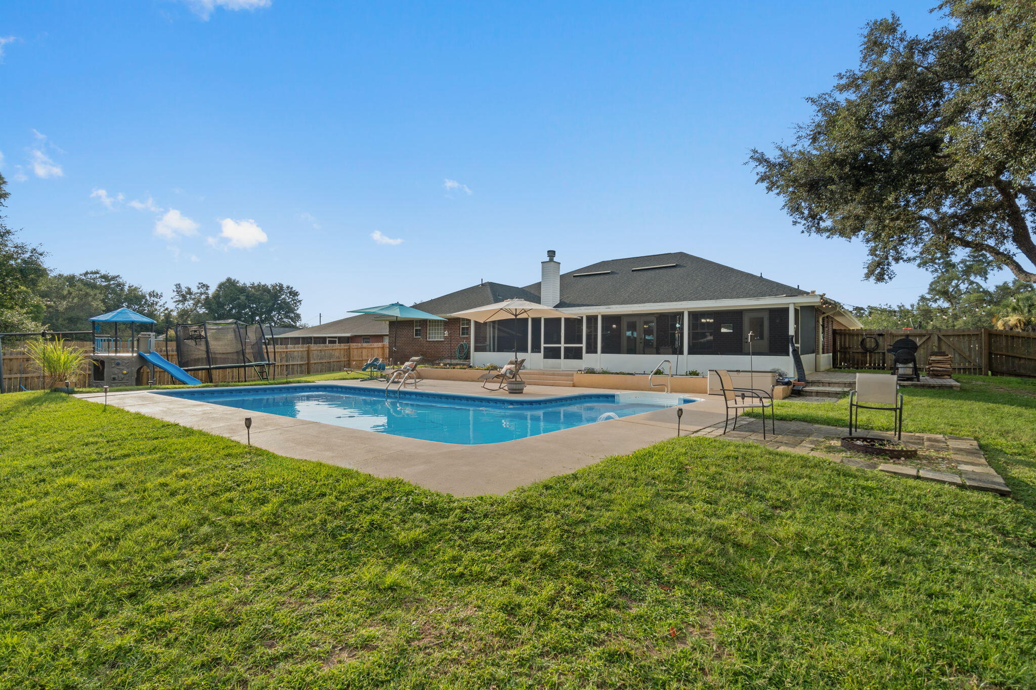 Welcome home to this all-brick 4BD/3.5BA POOL home tucked away on a spacious 0.46-acre lot at the end of a dead end street in the popular Navarre neighborhood of Holley by the Sea community! Have peace of mind with a 2022 roof, a 2020 water heater, and 2018 HVAC. This thoughtfully designed and almost 3,000 sqft property features a dedicated office with French doors, a massive living room with a cozy fireplace, and an entertainer's dream backyard where you're sure to enjoy Florida summers! Pull in the driveway and appreciate the extended driveway pad with access to the double gate, perfect for pulling in your boat! Walk inside and you'll immediately love the large open living room and hard surface flooring extending throughout! The huge kitchen boasts granite countertops, black stainless appliances, a large island with bar seating, a walk-in pantry, and an oversized eat-in area. Enjoy coming home to your expansive primary suite complete with a trey ceiling and an en suite offering two walk-in closets, granite double vanities, a tiled walk-in shower, and a separate soaking tub. Three additional bedrooms offer generous space and oversized closets, with two well-appointed bathrooms with granite counters and tile flooring. Walk through the large pantry to the laundry room which includes a convenient half bath and outdoor access to the backyard. Enjoy relaxing (bug free!) on the 40x15 screened porch or experience the best of Florida living with the large L-shaped pool surrounded by a concrete deck with plenty of room for all your outdoor patio furniture! Roast s'mores over the fire pit, grill on the extended patio, admire your flower beds, and make memories on this fantastic property. Not only are you close to the Emerald Coast's sugar white sand beaches, but as a property owner you have access to top-tier amenities at Holley by the Sea's multi-million dollar recreation center!