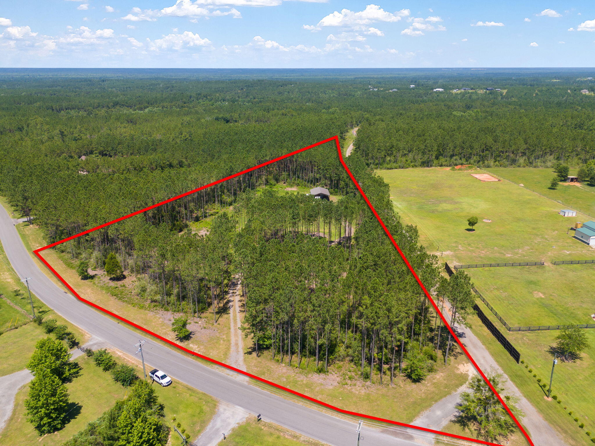 This 5-Acre lot is located on popular Ten Mile Rd & part of the sought-after Buffalo Creek Estates. It offers serene privacy surrounded by oak and pine trees & has an estimated 540 ft of paved road frontage on Ten Mile Rd & stretches out around 960 feet towards the back property.  There is a driveway that leads into 1.5-acres that have been cleared & would be an ideal spot to build a house or to use as an RV camp sight.  This property come equipped with a well/well house, electric/power, a washer/dryer along with loft space for added storage inside the Pole Barn thats 30 x 40ft- currently housing an RV (which is also available for purchase separately- please inquire with listing agent for details).