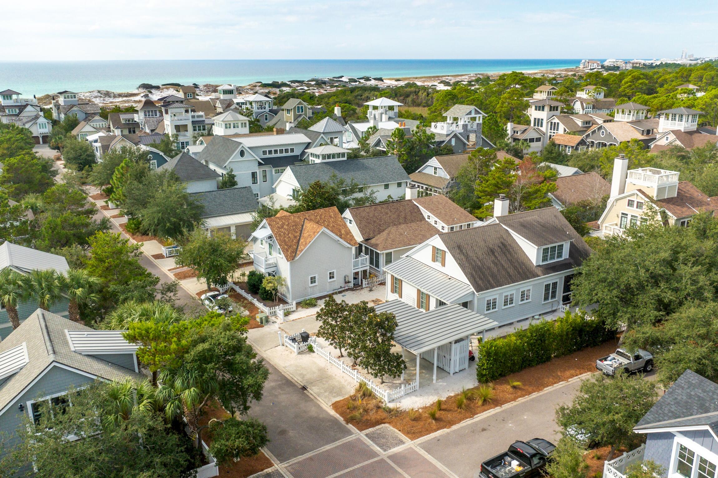 This is the time to make your legacy estate here on 30A behind the gates of Watersound Beach. This four-bedroom, five-bath masterpiece occupies a premier corner lot just steps from a private boardwalk to the Gulf. Designed for both sophistication and comfort, the home offers 320 square feet of inviting outdoor living and timeless architectural charm framed by white picket fences and coastal porches. The main level presents a grand open concept living area anchored by a chef's kitchen featuring BlueStar & Sub-Zero appliances, bespoke KraftMaid cabinetry, and quartz countertops. The primary suite is a true retreat with a spa-inspired bath--complete with a walk-in shower, separate tile tub, dual vanity, and a boutique-style dressing closet. Three additional guest suites upstairs provide private accommodations, each with its own ensuite bath and walk-in closet. Approved renderings for a garage, carriage house, and private pool allow for future expansion, elevating this residence into your own legacy estate. Sold fully furnished, rental-ready, with projections nearing $180K annually, this property captures the essence of the 30A lifestyle.