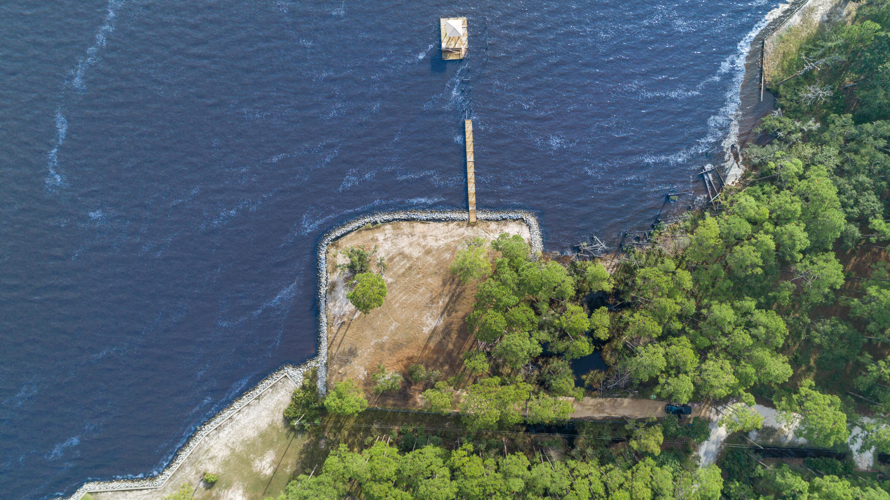 Stunning Bayfront lot measuring approximately 1/2 acre and 190' of water frontage, rip-rap is already in place to define the perfect site on which to orient your home. A dock with a covered slip exists. Perfectly located only 10 minutes from the White Sands of the Emerald Coast and 30a and 15 minutes from Grand Boulevard. Survey available upon request; Time to build your dream Home!
