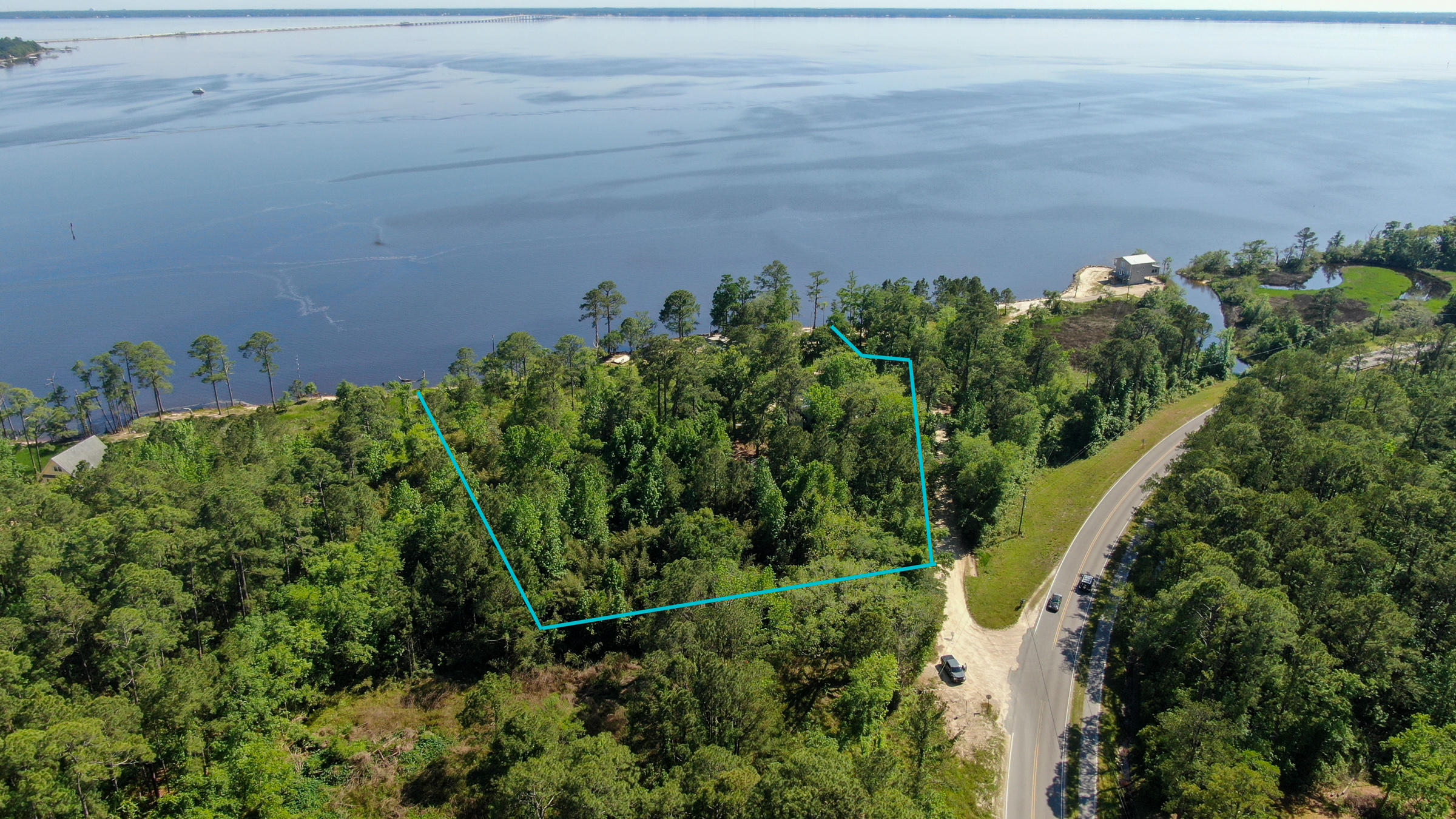 This large 2.65 acre waterfront property offers the perfect footprint for your customized dream home with 294 ft of unrestricted privacy for your own private oasis. Just a short boat ride across the bay and you can eat brunch or dinner at numerous waterfront restaurants. Enjoy paddle boarding, kayaking, and fishing off the banks or take a cruise on the bay in your boat. Currently this property offers 3 residential rental homes and they all have brand new roofs. The waterfront cottage offers 1,554 sq ft with 2 bedrooms and 1 bath. The second home offers 1,643 sq ft with 3 bedrooms and 2 bath. The third home offers 1,200 sq ft with 3 bedrooms and 1.5 bath. Options are plentiful with this fabulous waterfront property.