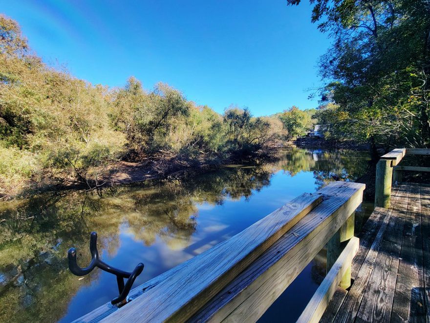 Nestled on 1 acre along the Choctawhatchee River in Walton County, this 2-bedroom, 1-bath cabin offers an old Florida tropical feel and a nature lover's paradise. Fully furnished with an open front porch, covered rear porch, large separate covered and partially screened patio for entertaining, dock, and new metal shed/garage, small block outbuilding. Off a winding freshly paved road surrounded by mature trees & right near a county boat ramp, freshwater springs; river eventually  leads to the Choctawhatchee Bay & Gulf of America. The lot has a small portion across the street from the gate entrance for additional parking. Approximately 50 minute drive to the beach. Buyer to perform own due diligence.