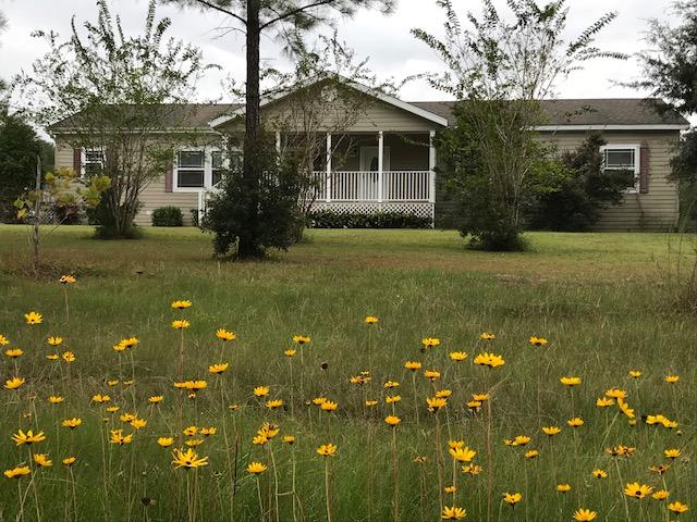 One of the nicest Manufactured Homes I have ever seen! Great floor plan, 9 ft, ceiling ht., spacious rooms, walk-in closets in Each Bedroom - ADDITIONAL ROOM THAT COULD BE A BEDROOM!!!! Spacious Front kitchen and Dining area, Ample, NICE cabinets plus pantry - Range 4 Yrs. old. ref., 9 yrs old. Fireplace is wood burning, but has a gas line so gas logs can be added. Nice large Covered Front Porch and large covered DECK that is the same level as the Above Ground Pool - great place to relax and enjoy! The exterior walls are 2 X 6, and the siding is Hardy Board, Shingles Dimensional. The way the property is situated, no one can built near to the Right. Full Acre! CL Fenced back yard for children or pets! NOTE: SELLER IS GIVING $4,000 FLOORING ALLOWANCE. Great price for this amount of SF