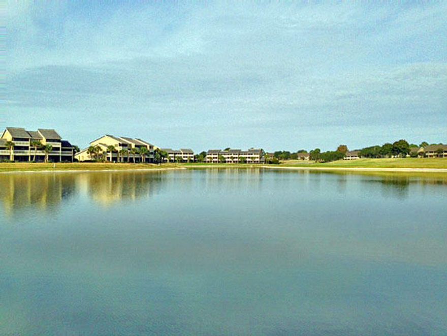 SENSITIVE TO CONDO SOUNDS. END UNIT OFFERS EXTRAORDINARY PRIVATE MASTER SUITE WITH NO ATTACHED WALLS & NO UNIT ABOVE. OFFERS FRENCH DOORS OPENING ONTO SCREENED PRIVATE PATIO OVERLOOKING STEWART LAKE WITH AMAZING SUNRISES. This first floor property offers 10' ceilings, crown molding, tile in living room, kitchen, and dining, with beautiful hardwood floor in all bedrooms. Master bath has garden Whirlpool tub, separate shower, walk in closet designed for year round living, and entrance easily accessible for those with handicaps. Treated with loving care and immaculate. Ready to move in for the retirees, year rounder, and/or investor looking for their slice of heaven with gated community offering 2000 ft of beach, on-site golf, tennis, water sports, bike rentals and restaurants.