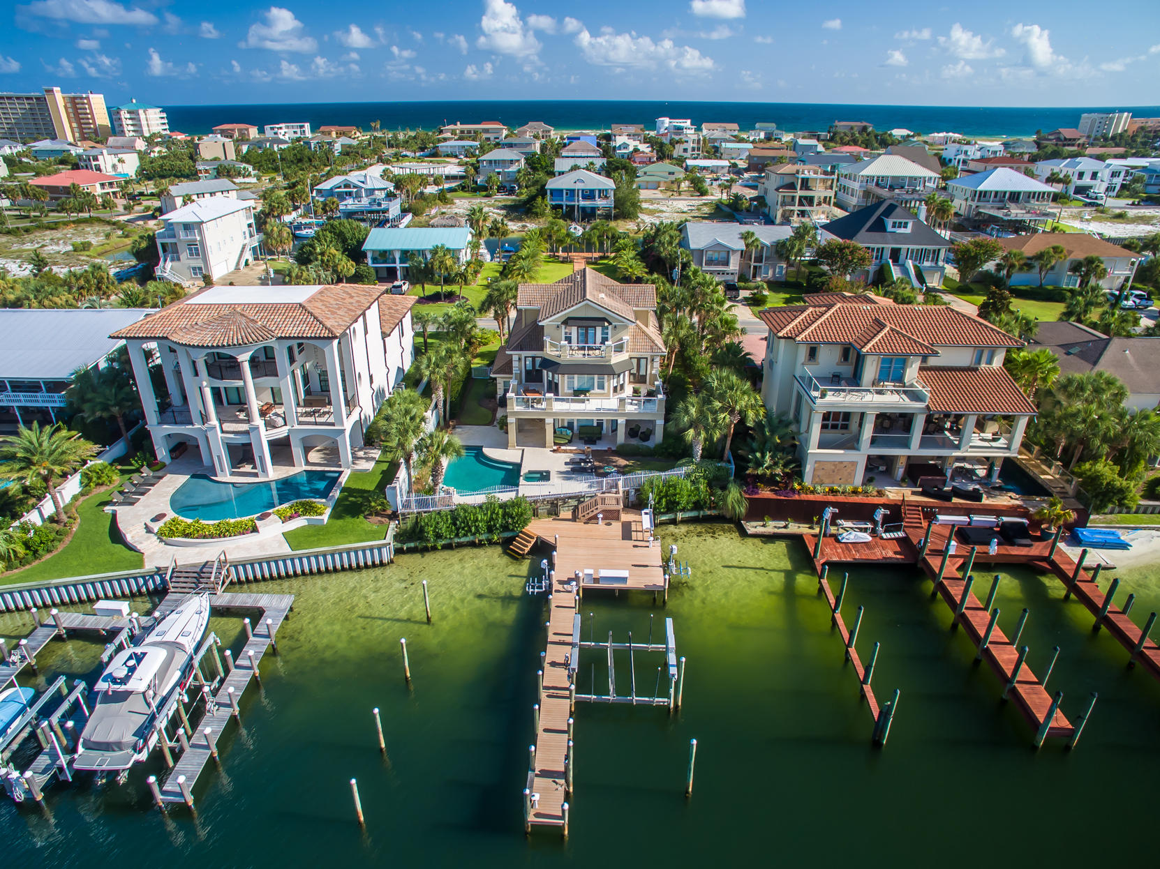 Attractive 3-story home offers every convenience for an active harbor-front lifestyle! This beautiful residence enjoys a great location toward the eastern (quiet) end of Destin Harbor, including a fully equipped dock with boat lift and 2 jet ski lifts, a gorgeous pool and hot tub, and a large sun deck with shaded patio areas.The first level, which includes a kitchen and living area, 2 bedrooms, and a full bath with direct access from the patio, could be used as a mostly self-contained space for guests, an adult child(ren), or elderly parent, if desired, or it could be used as casual family space, project rooms, etc. The main living and entertaining area on the second floor features an open kitchen/living room/dining area, large wrap-around balcony, great views, travertine floors...