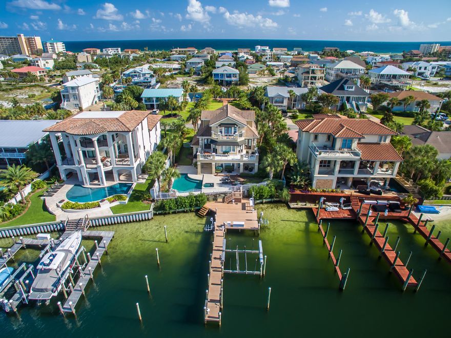 Attractive 3-story home offers every convenience for an active harbor-front lifestyle! This beautiful residence enjoys a great location toward the eastern (quiet) end of Destin Harbor, including a fully equipped dock with boat lift and 2 jet ski lifts, a gorgeous pool and hot tub, and a large sun deck with shaded patio areas.The first level, which includes a kitchen and living area, 2 bedrooms, and a full bath with direct access from the patio, could be used as a mostly self-contained space for guests, an adult child(ren), or elderly parent, if desired, or it could be used as casual family space, project rooms, etc. The main living and entertaining area on the second floor features an open kitchen/living room/dining area, large wrap-around balcony, great views, travertine floors...