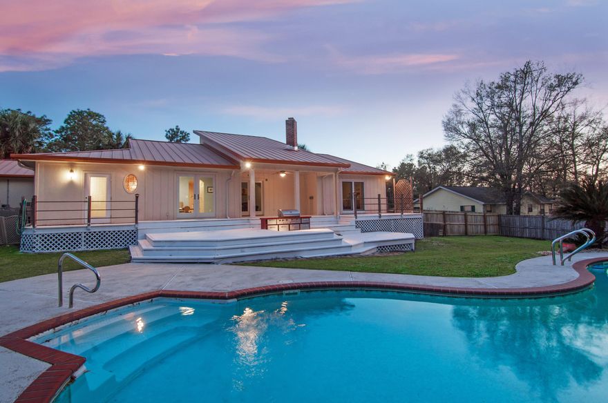 Palm trees accent the beautiful landscape and sparkling pool! From the moment you enter, enjoy the special features: Stained concrete flooring throughout is easy to care for, all vinyl cladd windows, 3 sets of Anderson double French doors, fully equipped Kitchen with stainless steel appliances- range w/warmer, 2nd oven (convection), microwave, large side by side Refrigerator, & wine refrigerator. Beautiful granite counters, built-in pantry & center island complete the picture!The Foyer opens to the Living Room, showcasing the corner stone fireplace & vaulted ceiling, with natural lighting from the clerestory windows & double French