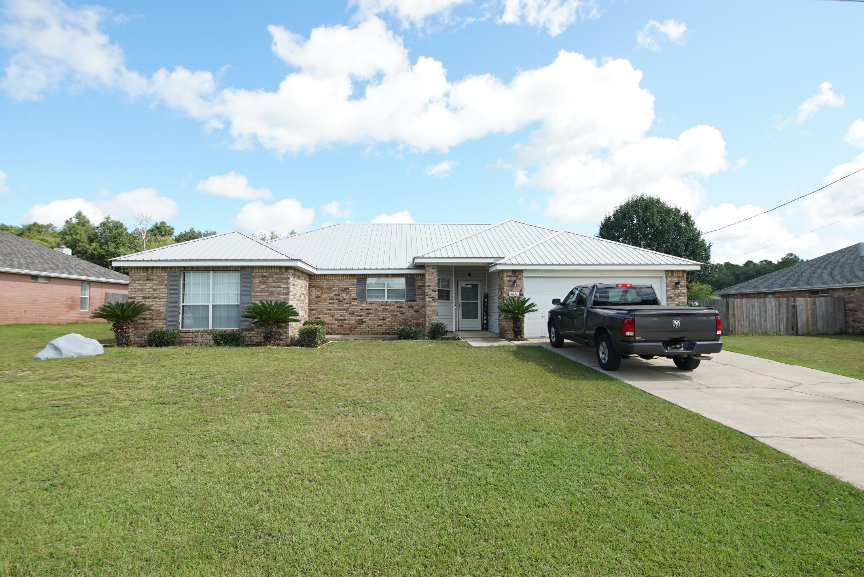 Everyone will love this well cared for beauty south of I-10. Seller installed a new metal roof, new HVAC, and updated the baths and kitchen in 2015. The eat-in kitchen is huge, with custom tile, island counter, big pantry, and cabinets with soft-close drawers. The living room is light and bright with wood flooring and a cozy fireplace for the occasional chilly night. The guest bedrooms can each accommodate a king bed. The other side of the home has the lush master suite, with spacious closets and a new shower surround. Everyone LOVES the 14x29 screened in porch, perfect for entertaining or hot tub. The massive backyard could easily fit a pool AND an outdoor kitchen. Even the garage has extra cabinets! Plus, there's a deep water well for the irrigation.