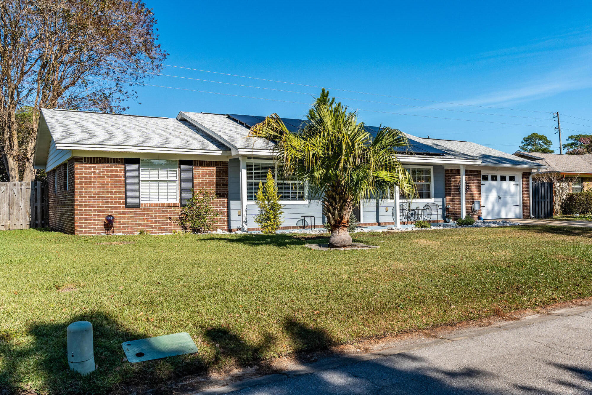 This fully updated brick beauty is turn-key ready for you! Inside, find an open floorplan bathed in light. There are two living areas, as well as a separate dining room. Your new kitchen has tons of space, gorgeous countertops, desk, and leads to an indoor laundry room. The guest bedrooms are more than ample, across from the updated guest bathroom with walk in shower. The primary bedroom easily fits a king bed, has a huge closet, the ensuite features a walk in shower. The enclosed Florida room leads to a privacy fenced backyard perfect for dogs, people, just you, but no llamas. PAID OFF solar panels (on a 2017 roof) mean a power bill @ $40 a month. There's a 30amp RV outlet next to the garage and a 5' wide gate. Offering $5000 Any Way money, home warranty, transferable termite bond.