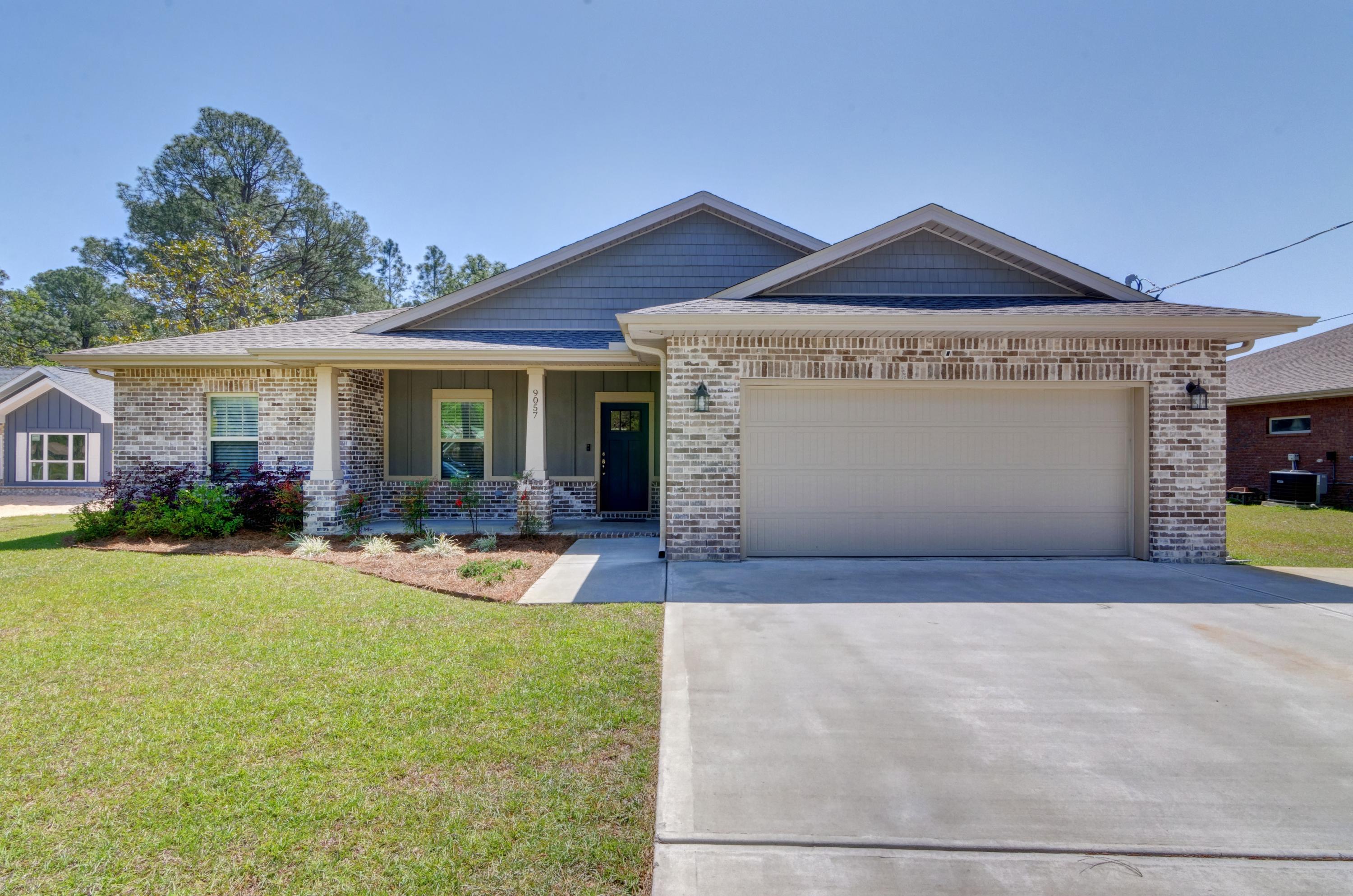 Better than new home located in a prime east Navarre location with stunning upgrades throughout! Clad with the timeless durability of brick, cement fiber board accents, and an architectural shingled roof, from the moment you pull up to the extended driveway pad and take in the tasteful landscaping and the spacious front porch you'll fall in love! Enter the front door and you'll find soaring ceilings with a trey ceiling and a fantastic long entry way. Custom paint color is accented with a wide baseboard, beautiful crown molding, and spectacular tray ceiling accents in the master bedroom, dining and entry area. Transom windows over the hall entryways provide a high end custom touch, along with the bedroom accent walls. The large living room is open to the stunning kitchen showcasing