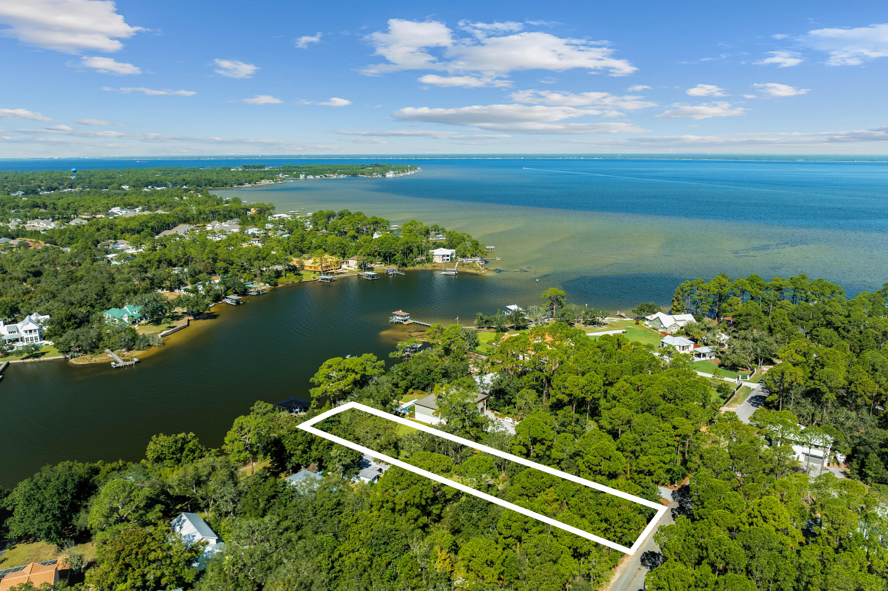 Tucked away behind private gates, this extraordinary waterfront estate lot redefines luxury coastal living on Hewett Bayou with .83 acres of prime bayfront land, 85 feet of year-round deep water frontage, and an impeccably designed dock--crafted for those who live life on the water. A winding drive meanders beneath a lush canopy of live oaks and towering pines, setting the stage for an estate that is both exquisite and private. For the dedicated boating enthusiast, this estate is unmatched in its offerings. This 85' x 407' lot provides unparalleled privacy and space, while the fully equipped dock - boasting a 12,000-lb. covered boat lift, fresh water, power, and flow-through platform, allows for seamless docking, world-class fishing, and endless days on the open water. A full composite-decking dock ensures both durability and timeless appeal, and the deep water well provides virtually rust free water.
As the sun melts into the horizon, the waterfront transforms into a serene masterpiece, casting breathtaking golden reflections across the bayou.
The option to create a magnificent family compound is available by combining with the adjacent home and lot for sale, effectively doubling the size to 1.66 acres.
Fine dining, luxury shopping and leading hospital and medical care are just minutes away. This exclusive retreat is a once-in-a-lifetime opportunity to build your own coastal sanctuary, where boating, fishing, and effortless luxury converge in perfect harmony.