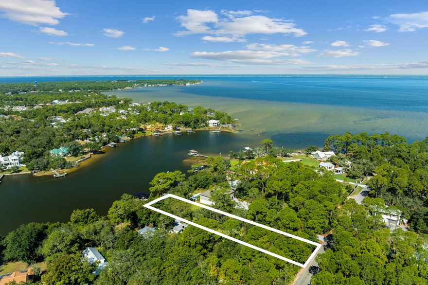 Tucked away behind private gates, this extraordinary waterfront estate lot redefines luxury coastal living on Hewett Bayou with .83 acres of prime bayfront land, 85 feet of year-round deep water frontage, and an impeccably designed dock--crafted for those who live life on the water. A winding drive meanders beneath a lush canopy of live oaks and towering pines, setting the stage for an estate that is both exquisite and private. For the dedicated boating enthusiast, this estate is unmatched in its offerings. This 85' x 407' lot provides unparalleled privacy and space, while the fully equipped dock - boasting a 12,000-lb. covered boat lift, fresh water, power, and flow-through platform, allows for seamless docking, world-class fishing, and endless days on the open water. A full composite-decking dock ensures both durability and timeless appeal, and the deep water well provides virtually rust free water.

As the sun melts into the horizon, the waterfront transforms into a serene masterpiece, casting breathtaking golden reflections across the bayou.

The option to create a magnificent family compound is available by combining with the adjacent home and lot for sale, effectively doubling the size to 1.66 acres.

Fine dining, luxury shopping and leading hospital and medical care are just minutes away. This exclusive retreat is a once-in-a-lifetime opportunity to build your own coastal sanctuary, where boating, fishing, and effortless luxury converge in perfect harmony.