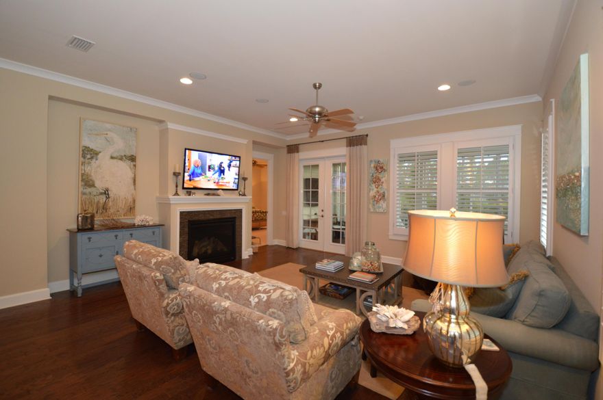 This home is delightful, full of additional items added to the home after the purchase. In the morning room off the kitchen is a custom designed/built in banquette with cushions that match the cornice board. All the windows either have custom plantation shutters or woven wood blinds. The kitchen has custom cabinetry with pull out drawers and even a pull out cutting board. Stainless steel appliances (a gas stove) and a beautiful backsplash compliment the granite and wood floors. The oversized granite island has bar seating. In the great room there is a gas fireplace, with French doors leading out onto the screened porch with TV Mount and Sunsetter shade. The back of the house looks onto a lovely green space, all landscaping is natural and easy to maintain. Furniture may be purchased extra.