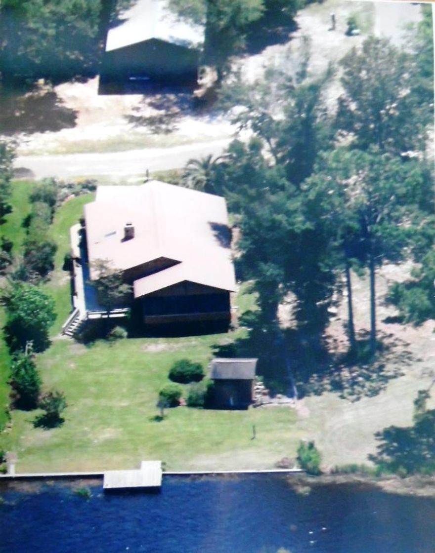 PRICE REDUCED - SELLER MOTIVATED!*WATERFRONT* 2 properties for the price of one!! Waterfront home and another lot w/24X34 garage/storage bldg! Majestic views of Juniper Lake - a 640 acre lake known for record bass/bream fishing! Located on Juniper Island, this cottage has special appeal w/water views from almost every room in the home.A The interior features many new upgrades. The Kitchen has wood cabinetry w/ granite countertops, custom tile backsplash, large pantry and upgraded appliances. The spacious great room/dining area share a woodburning fireplace and have a wall of windows overlooking the water. Three bedrooms and a sizable laundry room add to the cozy feel this home offers. The oversized screened porch is really another living area-the views and breezes are wonderful! The exterior is designed for low maintenance and recently replaced features include cedar siding, metal roof, heat/ac unit and septic systemThe professionally landscaped yard is designed to provide addl privacy along the property lines and has native plants blooming profusely! Fully sodded down to the water w/a sprinkler system that is provided water by the lake.  A storage bldg and boat/fishing dock are in place for your enjoyment! Included w/this home is a 24X34 2 car garage/storage bldg on another large lot located directly across the street. This offers great storage for cars, boats, tools, workshop, etc. This property is set up perfectly for a permanent residence or ideal as a second home vacation retreat!
All dimensions are approximate and should be verified by Buyer.