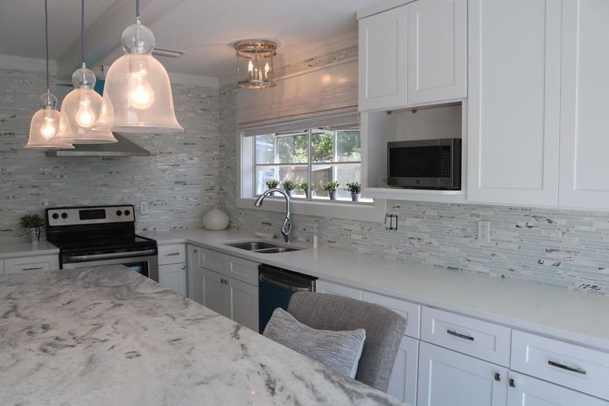 Stunning home with 70 feet on deep water canal leading to Bay. Surrounded by high end homes. No HOA's. Ship Lap in every room, Farm house doors, marble and Quartz kitchen and bathrooms. Large doors to water from kitchen and master bedroom. Views from almost all rooms. New roof, paint and beautiful decor. Room for a huge pool in the backyard that is already fenced.