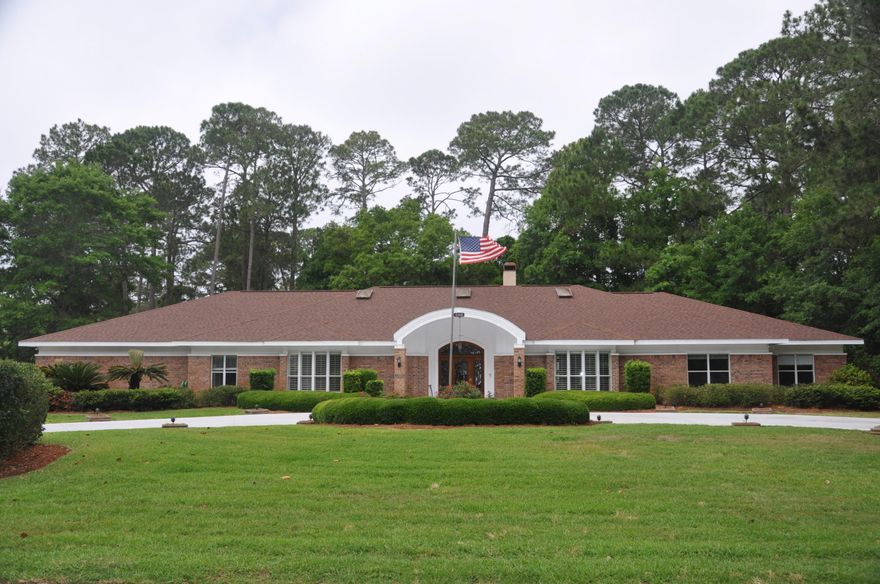 Stately, custom built, 5 bedroom/5 bath brick home on double lot in popular Bluewater Bay. Impressive front elevation with circular drive, center flagpole, and side entry 3 car garage. Professionally landscaped all around. Large tiled entry foyer with formal dining room and formal living room on each side. To the right is an entertainment area with wet bar, refrigerator and ice maker. This room leads out to the loggia (outdoor Gallery area) and pool deck. Bright kitchen features granite, double ovens, walk in pantry, generous cabinetry, center island with veggie sink. Breakfast area overlooks the gunite pool. Butler pantry between kitchen and dining room. Split floor plan with large master bedroom with 3 closets, one is cedar lined. also sitting area with French door to pool.
