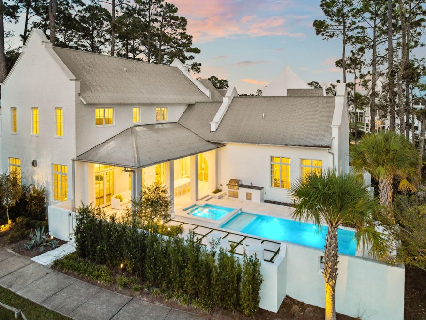 Modern elegance meets timeless coastal design. This 4,360-square-foot home offers five bedrooms, five full bathrooms, and two half bathrooms, thoughtfully arranged with a unique floorplan that places the primary suite on the main level for convenience and privacy. Expansive windows, soaring ceilings, and refined finishes fill the interiors with natural light, while the open-concept layout flows seamlessly from a striking marble-accented fireplace wall and spacious living area into a dining room anchored by a statement chandelier and a chef's kitchen complete with sleek cabinetry, a waterfall island, and professional-grade appliances. The primary suite is a serene retreat with vaulted ceilings, walls of windows, and a spa-inspired bath featuring designer finishes and a custom walk-in closet. Each additional bedroom is equally well-appointed, offering en suite baths and elevated details throughout. Outdoors, the private courtyard is a true sanctuary, complete with a sparkling pool, spa, built-in firepit, outdoor kitchen, and a convenient exterior powder bathrooman ideal setup for entertaining or quiet relaxation. Two garages add both function and storage, while peaceful lake views provide a sense of tranquility and connection to nature. Crisp white brick, clean architectural lines, and lush landscaping enhance the home's curb appeal and timeless style.

Set within the amenity-rich community of Churchill Oaks, residents enjoy exclusive access to a deep-water marina, bayfront clubhouse, state-of-the-art fitness center, and resort-style pools overlooking Hogtown Bayou. With its thoughtful design, luxurious finishes, and private setting, 68 Perrin represents the perfect balance of sophistication, comfort, and coastal living in one of 30A's most desirable waterfront enclaves.