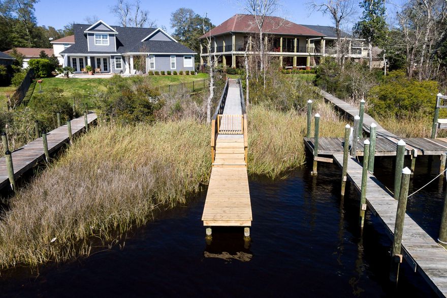 Neighborhood, neighborhood, neighborhood! This 17 home, New Orleans style subdivision has a close community feel and a community dock for private water access into Bluewater Bay.Walk into the open concept living area and kitchen combination equipped with stainless steal appliances, quartz counter tops, high ceilings and top of the line engineered hardwood flooring. There are 2 spacious bedrooms in the main home and a large laundry area. The master en-suite maintains double vanities, a large soaking tub and walk in shower, tile throughout and a custom closet!Have guests? Above the two car garage is a studio apartment with a small kitchen area, private bathroom, laundry hook ups, and balcony. Come enjoy Florida on a half acre lot with close access to the Destin Mid-Bay bridge!