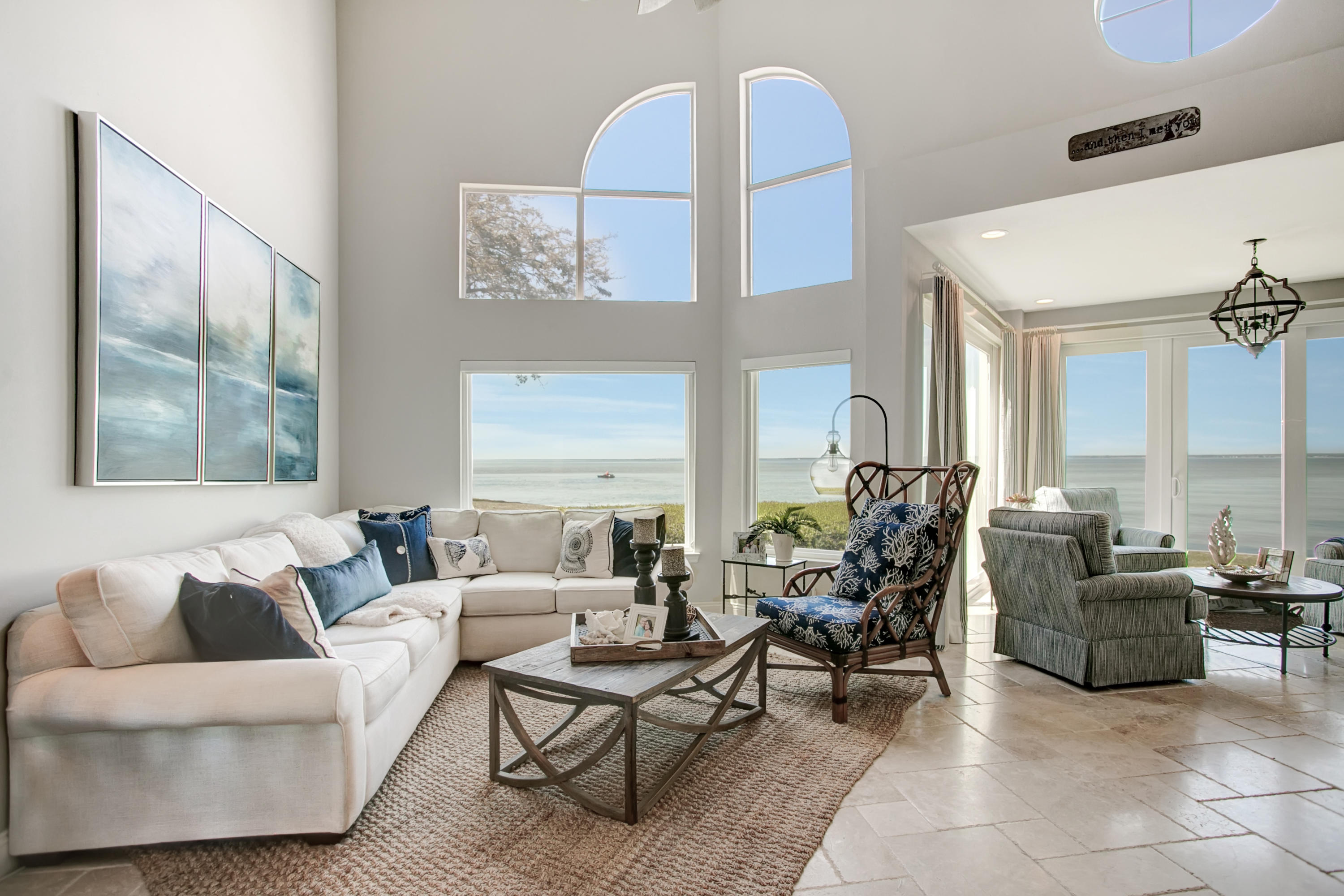 Exquisite waterfront townhome - nothing compares to it on the market and at this price point!  Incredible panoramic views of the bay from entire backside of home.  Direct water access to enjoy kayaking, paddle boarding and fishing from your back door or walk/bike 1 mile to beach.  Sip morning coffee or watch the gorgeous sunsets from the outdoor balcony.  Home has been completely remodeled with high-end, custom finishes throughout:  Tesoro travertine tile, wood floors and staircase, marble kitchen and baths, larger kitchen layout with custom cabinets with soft close drawers, newly enclosed interior sunroom (adding 150sf to the original 1,749sf), crown molding, dual shower master bath, and low VOC painted walls/ceiling.  All new windows, large hurricane-rated patio doors, kitchen & laundry