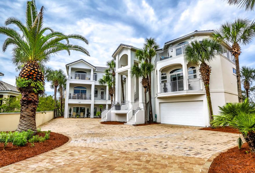 Masterly renovated, contemporary-style, lakefront residence with an infinity pool with swim-up bar, guesthouse, and Gulf views presents a fully orchestrated sensory experience. Luxury and nature blend in perfect harmony at Sea E O, a popular vacation rental. Both new and repeat rental guests booked $280,000 in rentals for 2016. Constructed by gutting and joining two adjacent properties while preserving the footprint of the original home, Sea E O is composed of a main home and a guesthouse, connected by a covered breezeway, which surveys the Destiny community lake. A lakefront infinity pool with swim-up bar, elevated spa, covered sitting area, gas fireplace, and outdoor kitchen create a dramatic visual outdoor living space.. The modern chef's kitchen in the main house offers custom cabinets, stainless steel Kitchen Aid appliances, a professional range, a large island and wet bar. Offering a linear fireplace and wet bar, the living area commands water views from its large wall of glass. The master suite, assuming the entire 3rd floor, features an expansive wraparound balcony with gulf and lake views. The master ensuite offers a custom tile shower and custom soaking tub. The guesthouse offers 6 bedrooms complete with baths, kitchen, laundry, and living area. Throughout the residence, expanses of glass frame vistas of the gulf and lake. Located right across the street from the beach on Scenic Gulf Drive, Destiny (West) is considered one of the most exclusive gated communities in Destin. Destiny is located between 2 freshwater lakes and amenities include the Destiny Yacht Club clubhouse complete with meeting areas and kitchen, workout room, fishing, pavilion/gazebo, picnic area, playground, pool and tennis.