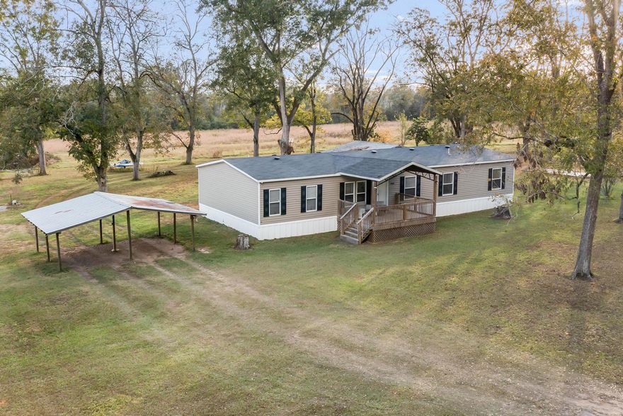 Discover your own serene retreat with this expansive  home featuring a covered front porch, open floorplan and 2,160 sq ft of living space, set on over 11+ acres of lush, private land. Designed for those who cherish comfort and outdoor living, this property offers a rich assortment of fruit trees and over 45 mature pecan trees, including Elliot, Moreland, and Stuart varieties--creating a personal orchard and a tranquil natural haven.  Seamless connectivity is assured with high-speed 1,000 Mbps internet, TV, home phone, and cell services provided by Spectrum. Enhanced security comes with a closed system home surveillance setup, featuring six audio-video night vision cameras for added peace of mind. Thoughtfully equipped, the property includes a 10-hp Amtrol water (con't pressure booster (installed in 2023), two city water taps, two power lines with transformers, and three septic systems: one for the main home, one on the east end, and another with a 12x26 concrete RV pad on the west side. Additional features include a 26x30 open barn with four stalls and power, a 28x20 covered parking area with two stalls, and a 20x24 covered shed on a concrete slab near the secondary home site. Just 7 minutes from Paxton School (K-12) and Lake Jackson at Florala State Park, and a quick 3-minute drive to Britton Hill, Florida's highest elevation point, with trails, playgrounds, and picnic areas. Whether you're unwinding in the spacious interior or exploring the scenic landscape, this home provides ample room for everyone and everything. A perfect blend of rural charm and modern utility, this property is ready to support multiple lifestyles and future growth. Don't miss this rare opportunityschedule your showing today and experience the potential and beauty of this exceptional property!